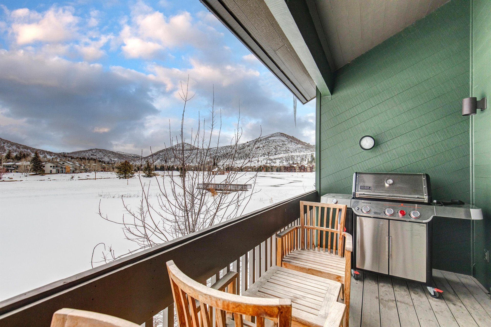 A private patio with a table, two chairs and BBQ gas grill where you can take in the mountain and lake views.
