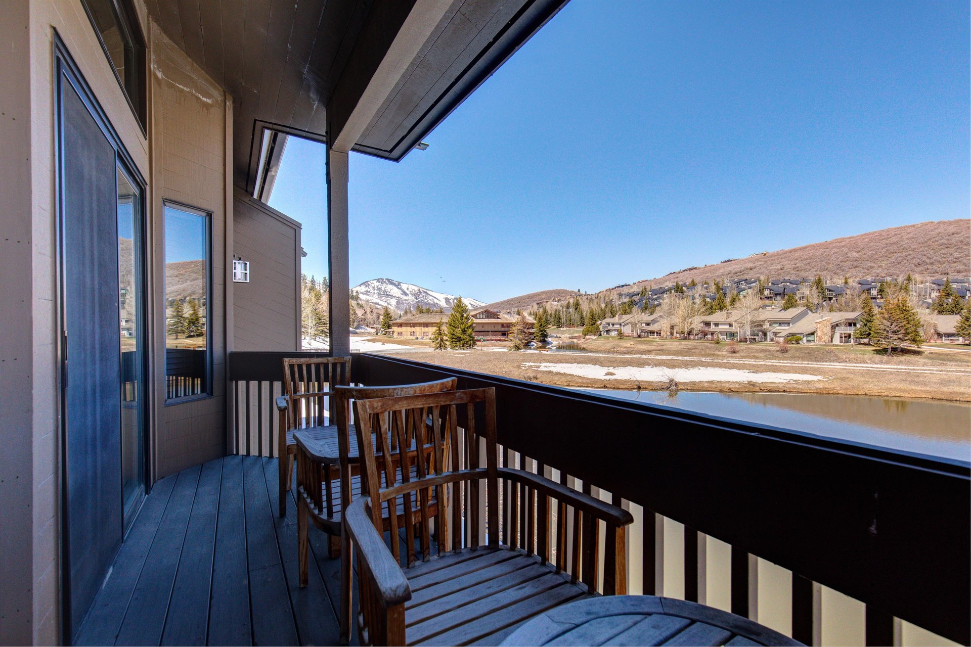 A private patio with a table, two chairs, the lake views and the snow melting out in the spring.