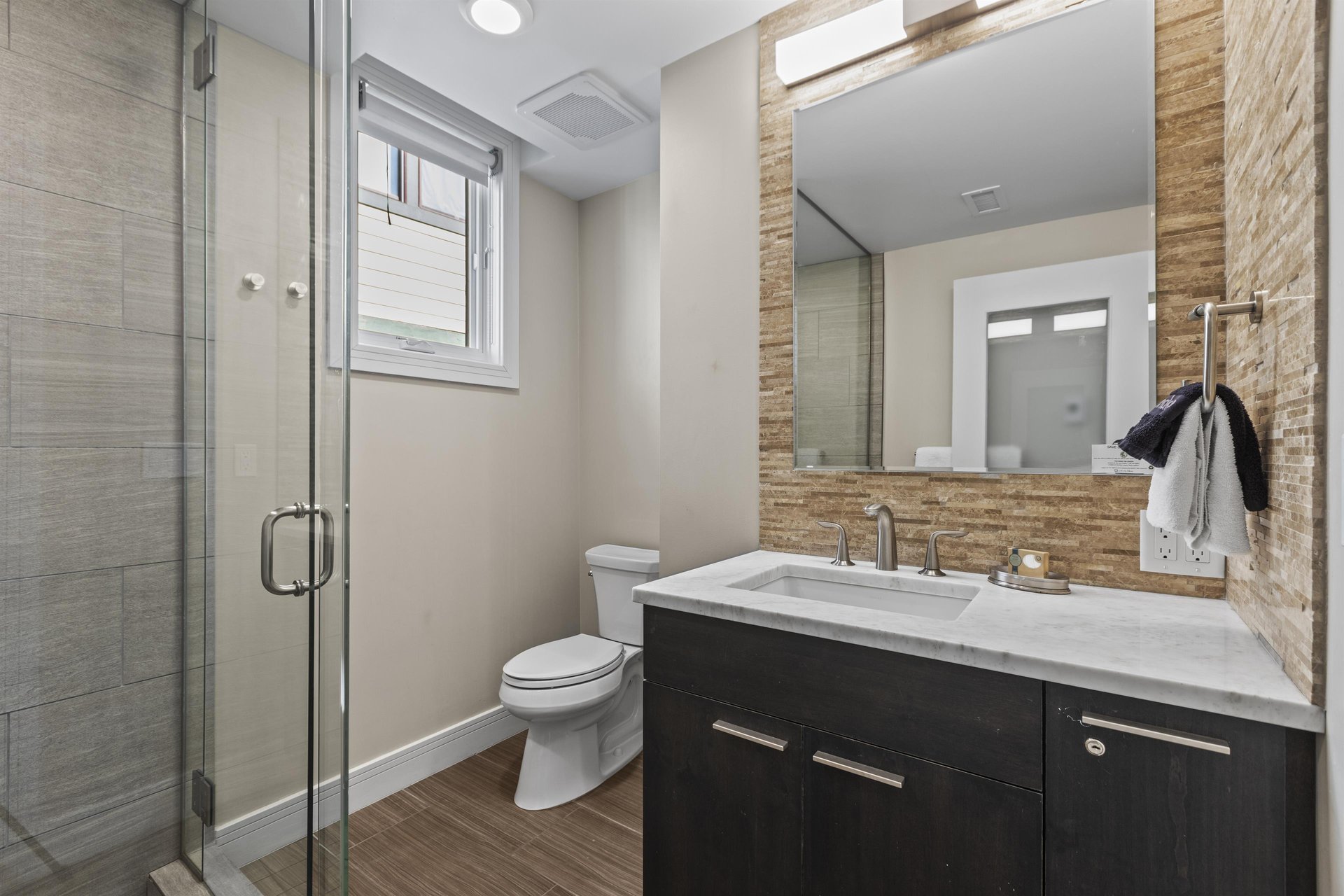 The en suite bathroom with a walk in shower and single sink vanity.