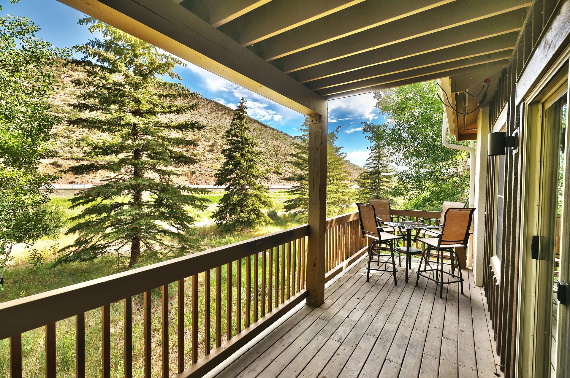 Main level private wood deck and covered patio with bistro table and chairs