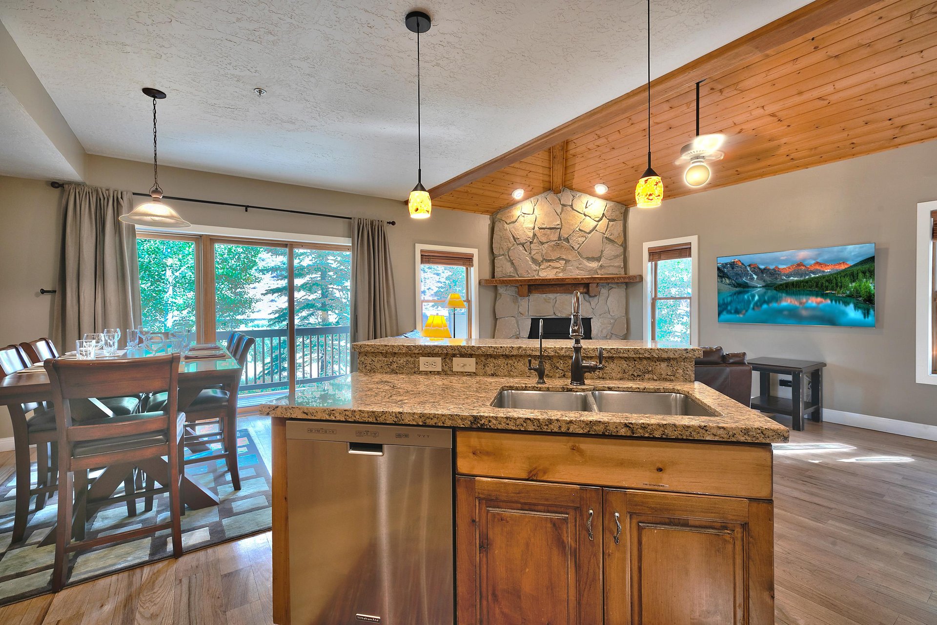 Twotiered kitchen island with granite countertops, wooden cabinets and stainless steel dishwasher