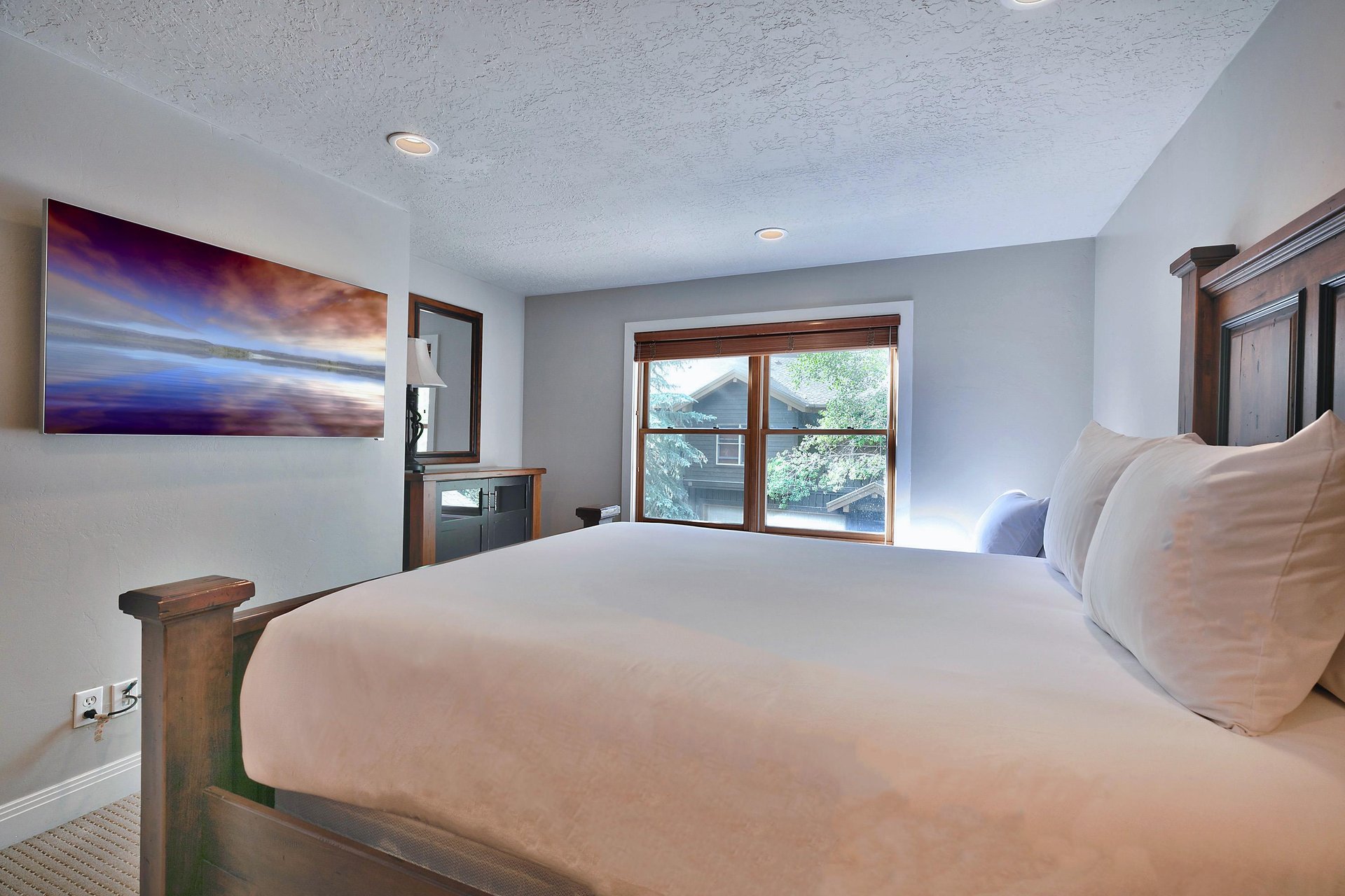 Guest bedroom with queen and wall mounted flat screen TV