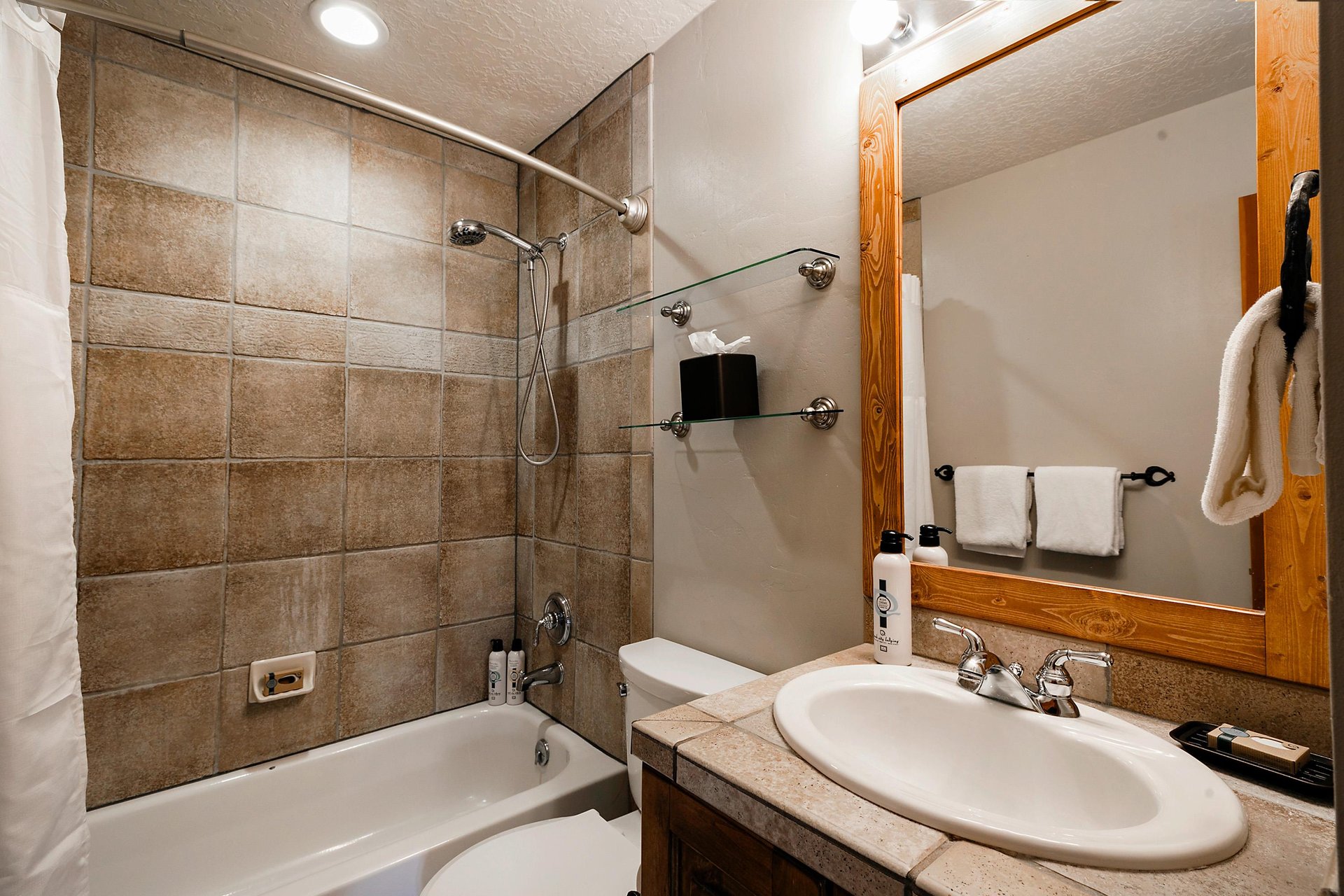 Full bathroom with tiled shower and handheld shower head unit