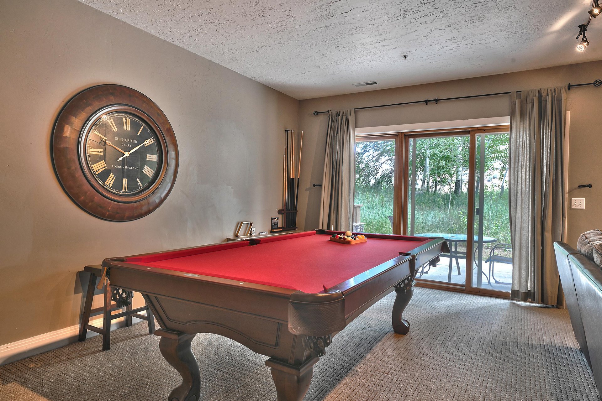 Enjoy a game of billiards in the den with striking red felt and wooden table, sliding glass door to private patio