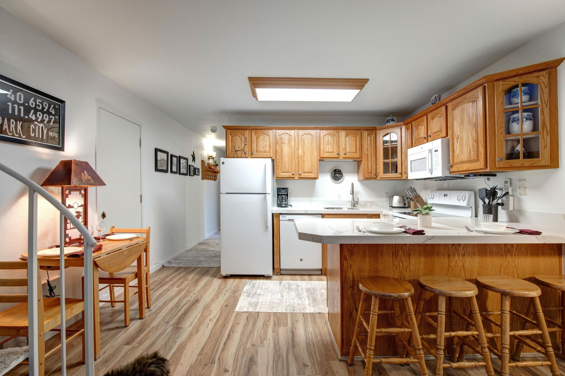 Your fully equipped kitchen features warm wood cabinetry, modern appliances, and a convenient breakfast bar where you can enjoy morning coffee or casual meals.