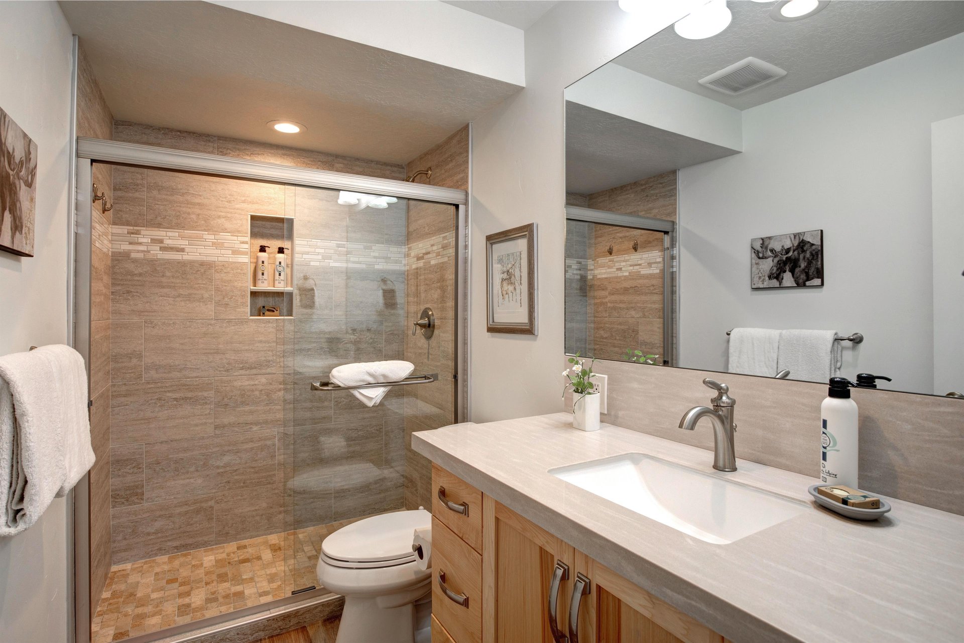 Indulge in your beautifully appointed bathroom featuring a spacious walkin shower, elegant stone tilework, and modern vanity with ample storage for all your essentials.