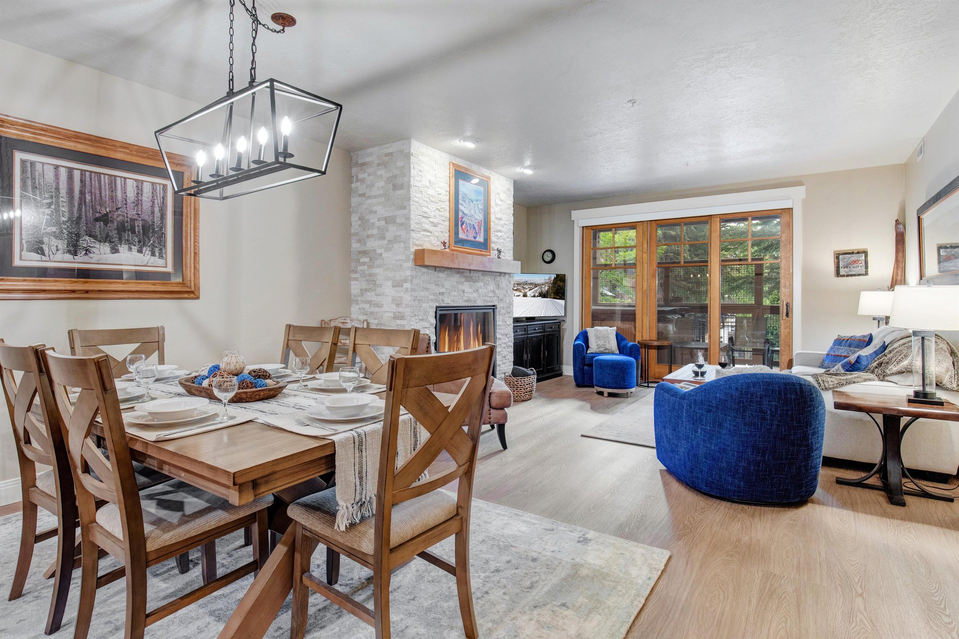 Gather around the dining table for meals and stories, then sink into plush seating by the fireplace. Large glass doors frame nature beyond, inviting relaxation in your mountain retreat.