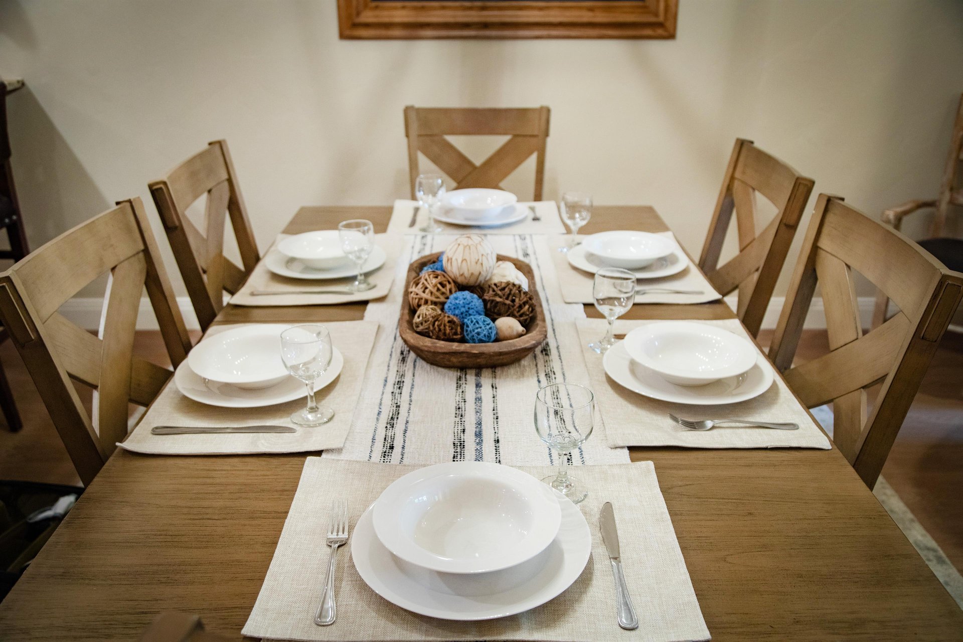 Gather around this beautifully set dining table for six, where every meal becomes a special occasion. The elegant place settings and warm wood tones create the perfect backdrop for your shared moments