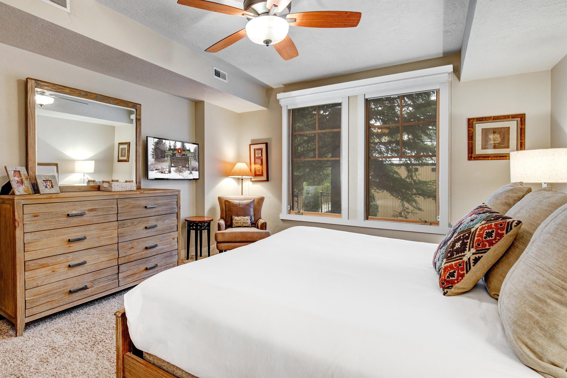 Sink into crisp linens and enjoy your favorite shows from the comfort of a plush bed, cooled by a gentle overhead fan and framed by peaceful mountain views through large windows.