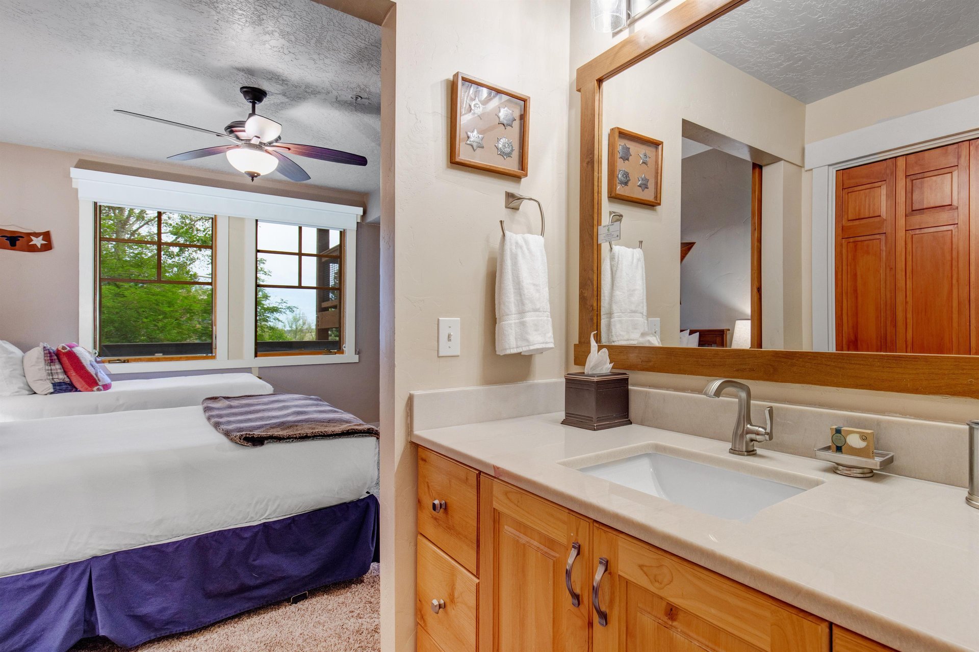 Your private ensuite features a clean vanity and fresh towels, with views of leafy greenery just outside—a perfect blend of comfort and natural serenity.