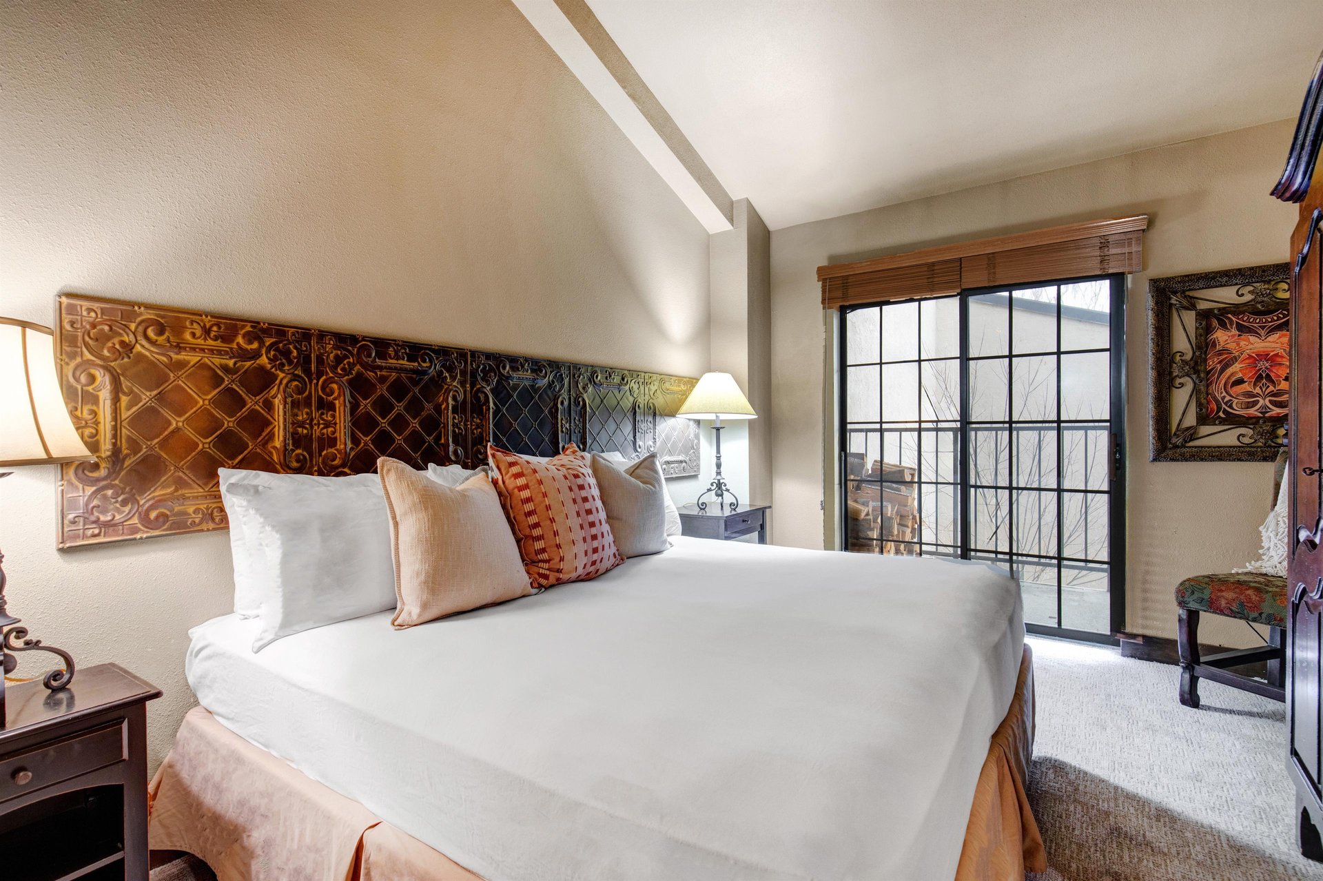 Sink into crisp white linens beneath ornate tin ceiling panels while city views frame your peaceful retreat.