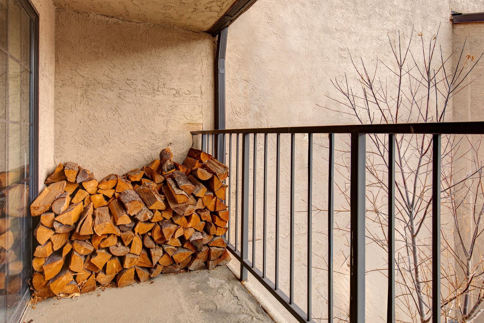 Your private balcony offers a cozy retreat with stacked firewood ready for those chilly evenings by the fireplace.