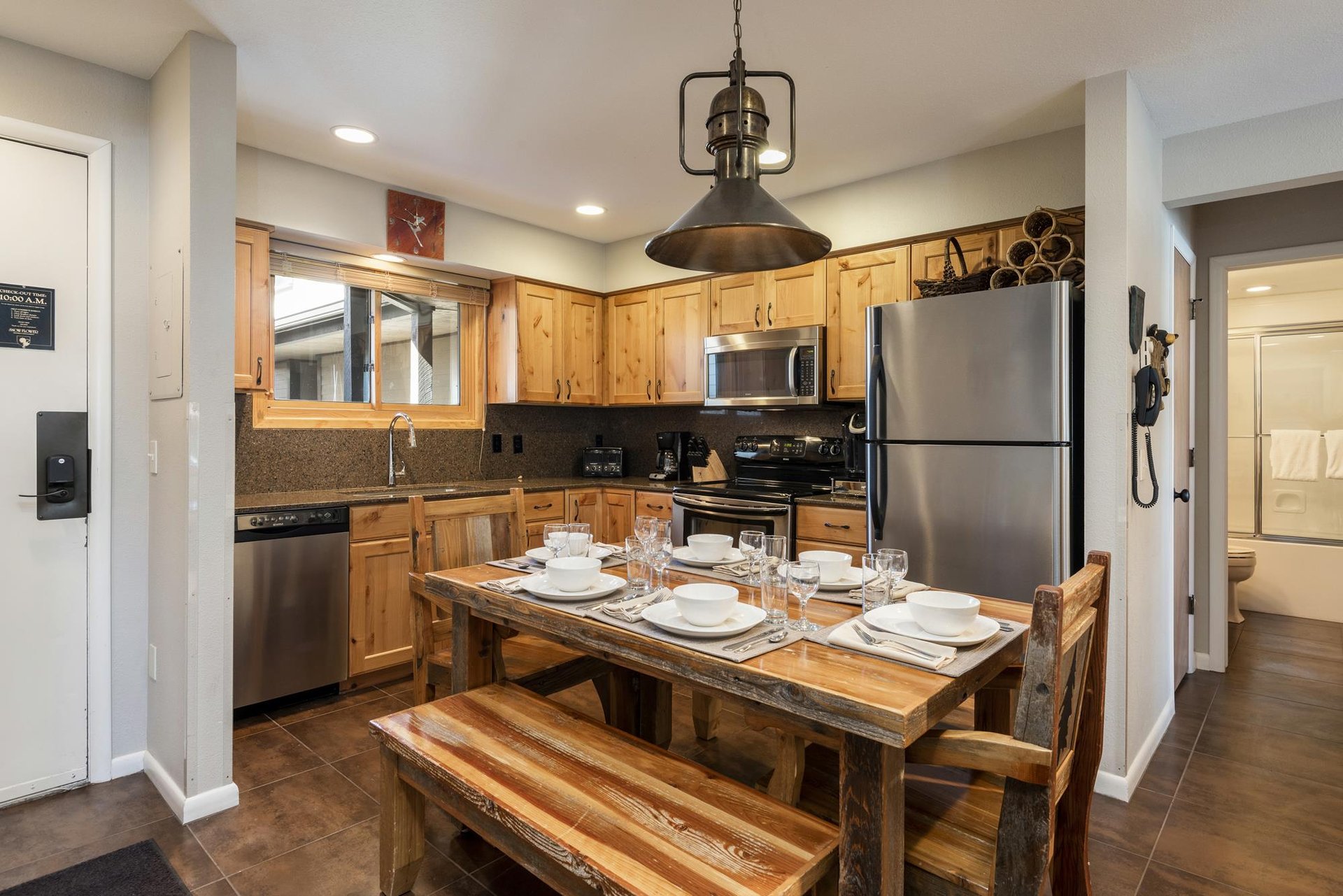 Fully equipped kitchen with wood cabinetry, stainless steel appliances and dining table that seats 6 people