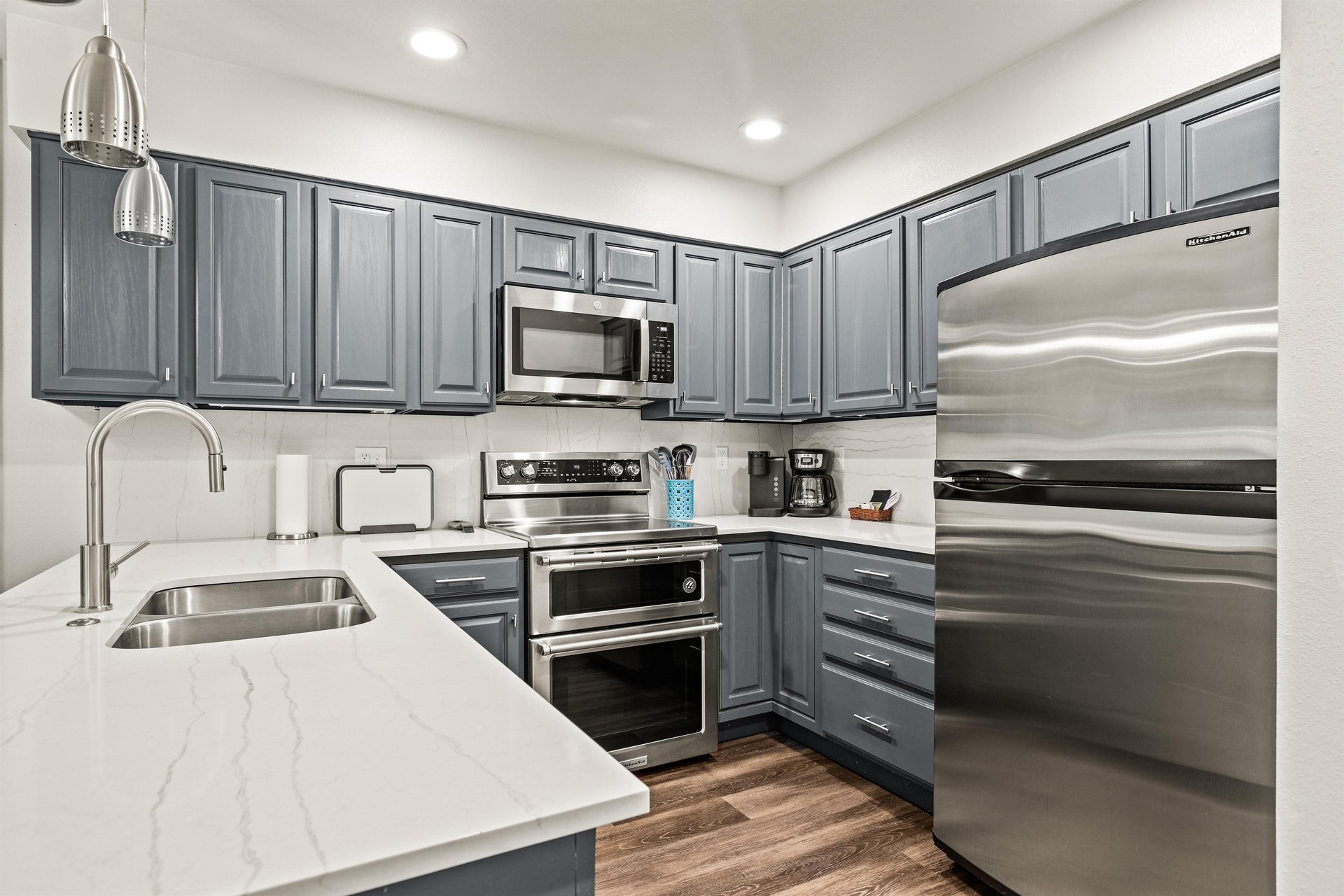 Modern Park City condo kitchen with quartz countertops, blue cabinets and stainless steel appliances