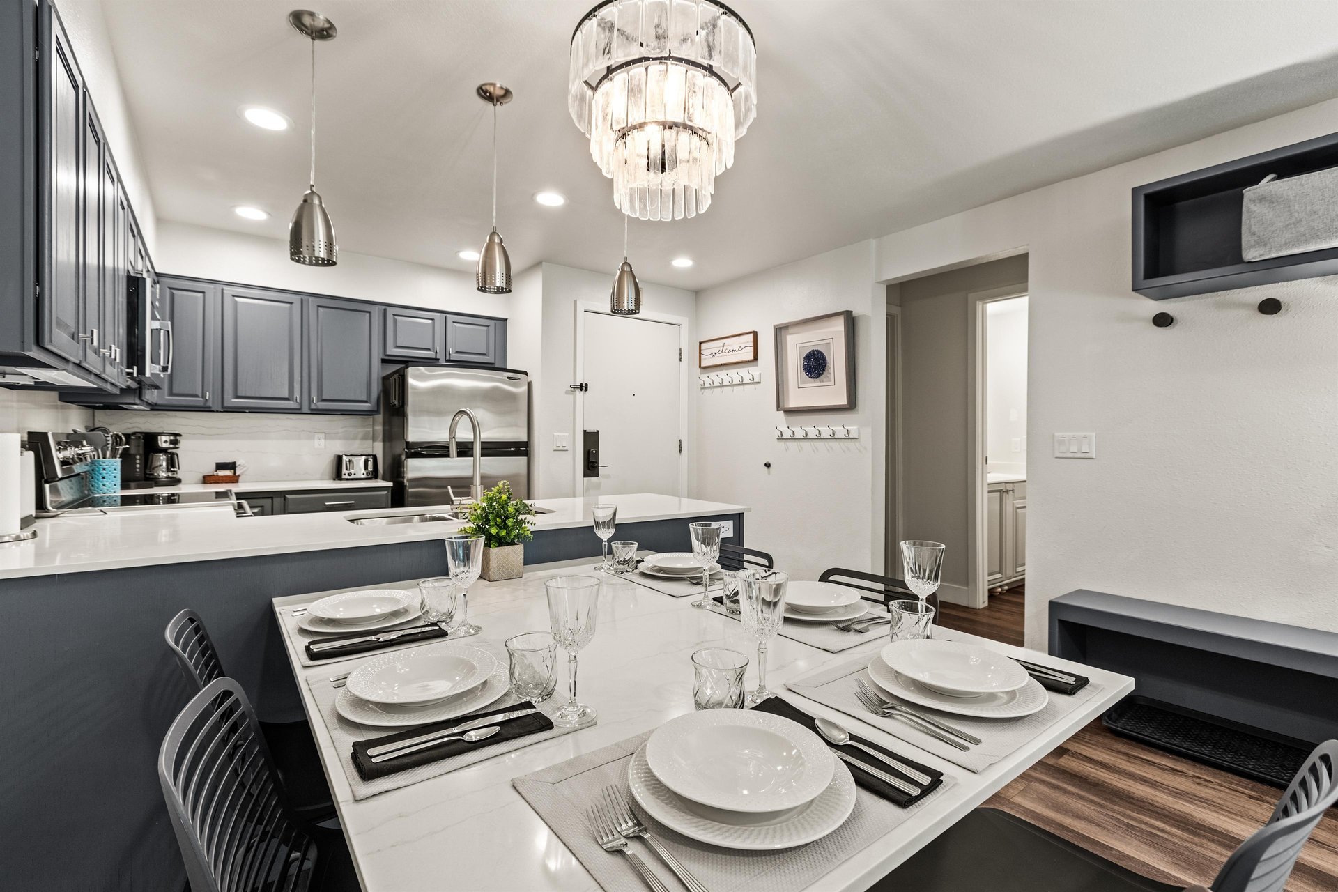 Dining area with seating for 6 people beside a modern kitchen and stainless appliances