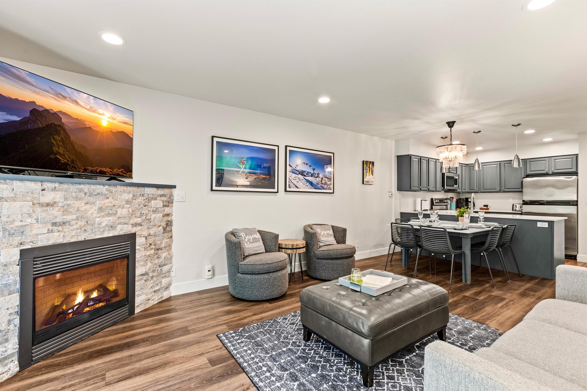 Open living and dining space with stone fireplace, comfortable seating and fully equipped kitchen