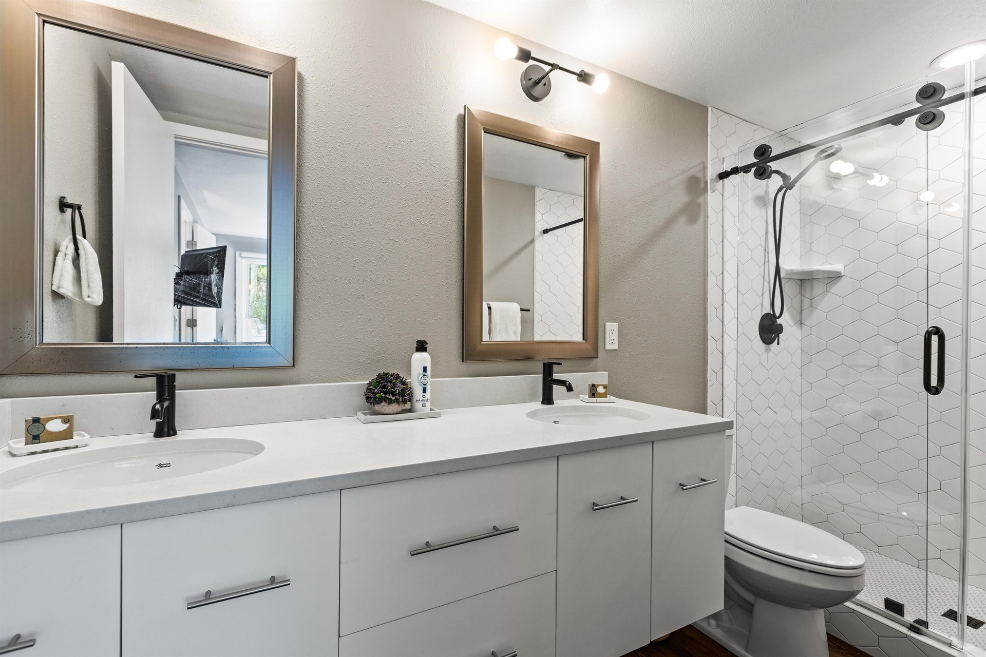 Modern bathroom with double vanity and glassenclosed walkin shower