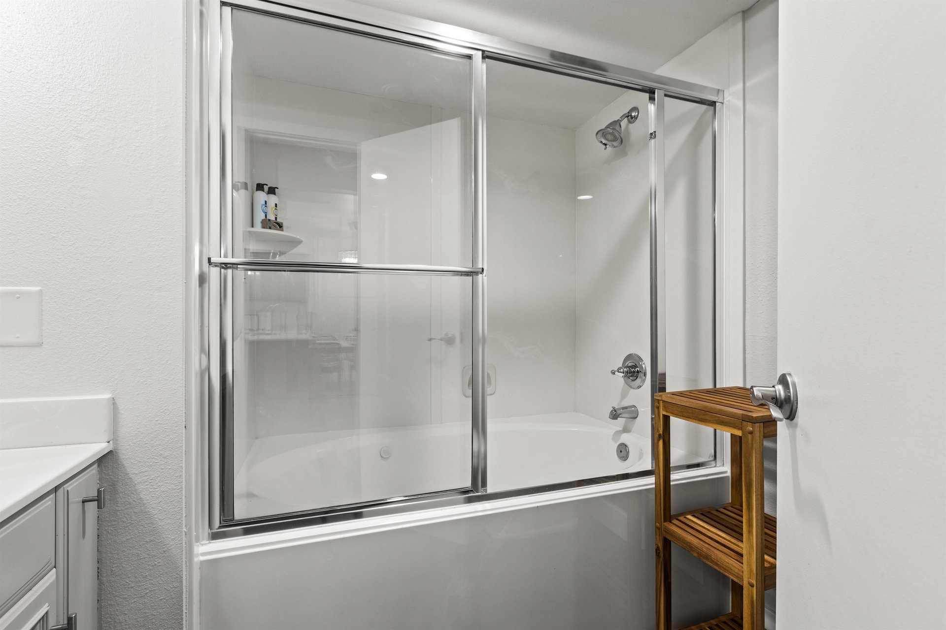 Guest bathroom tub and shower combination with sliding glass doors