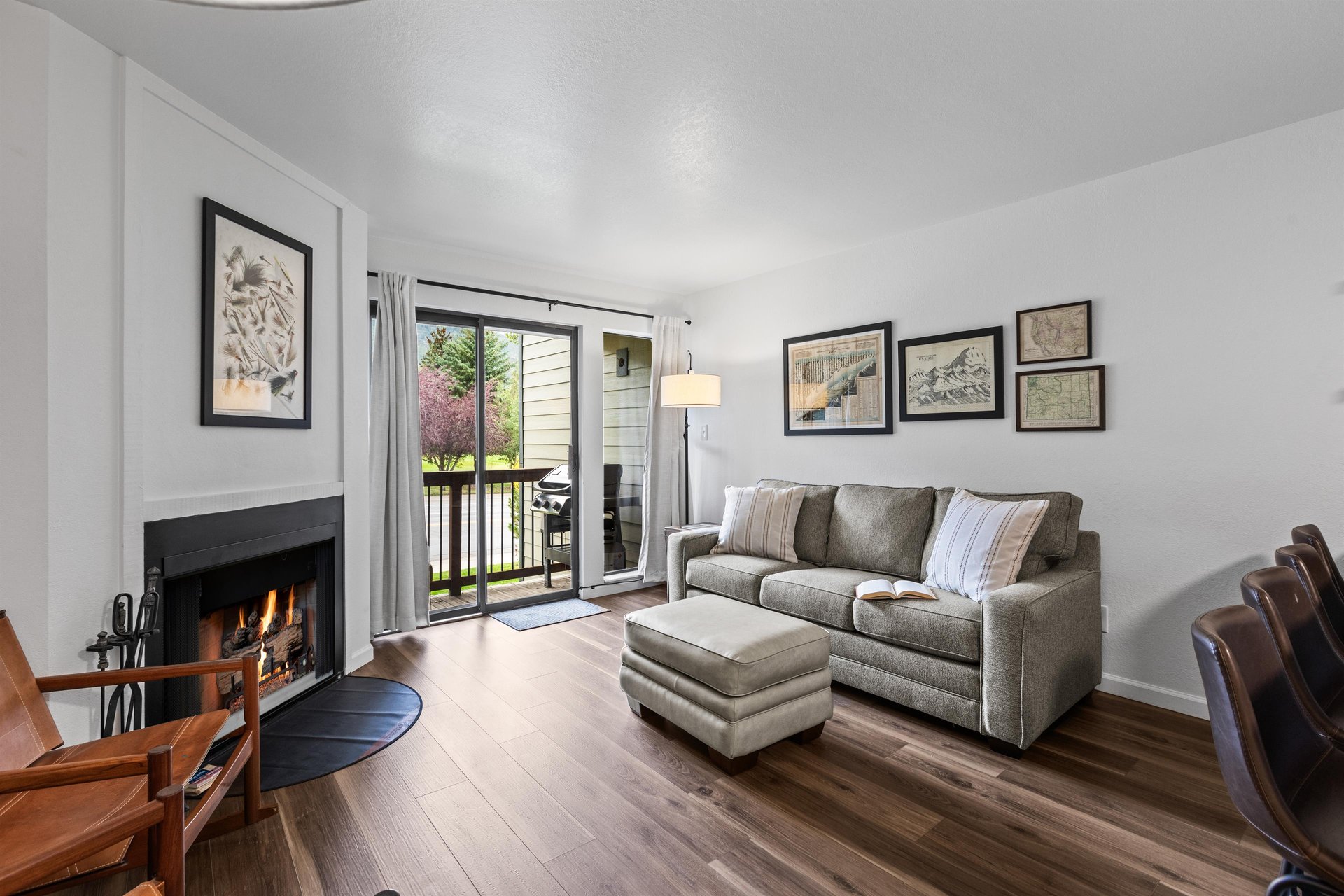 The living room has a comfortable sofa with stylish artwork hung above and sits next to the sliding glass doors.