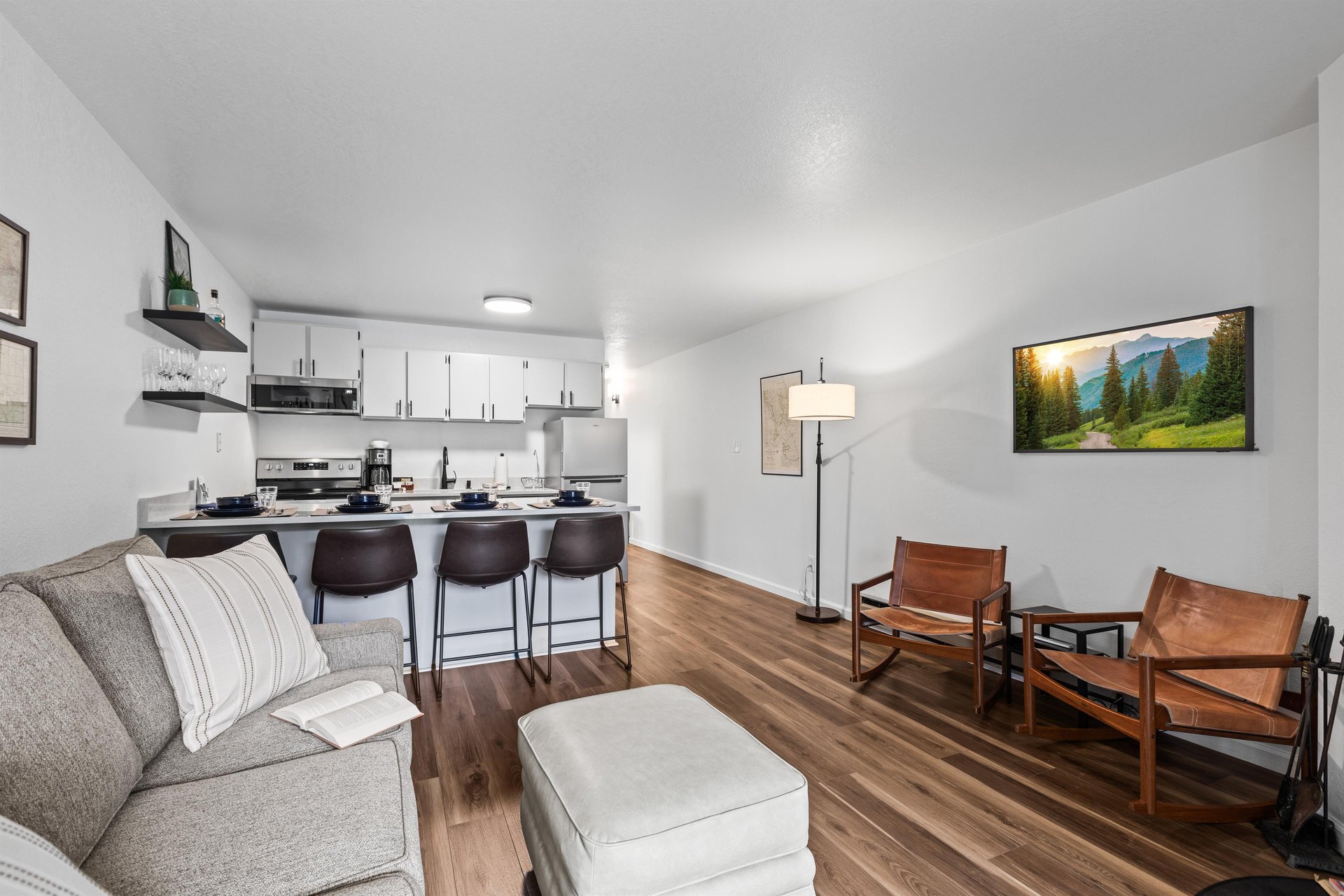 The open concept living room and kitchen with a breakfast bar with seating for four guests.