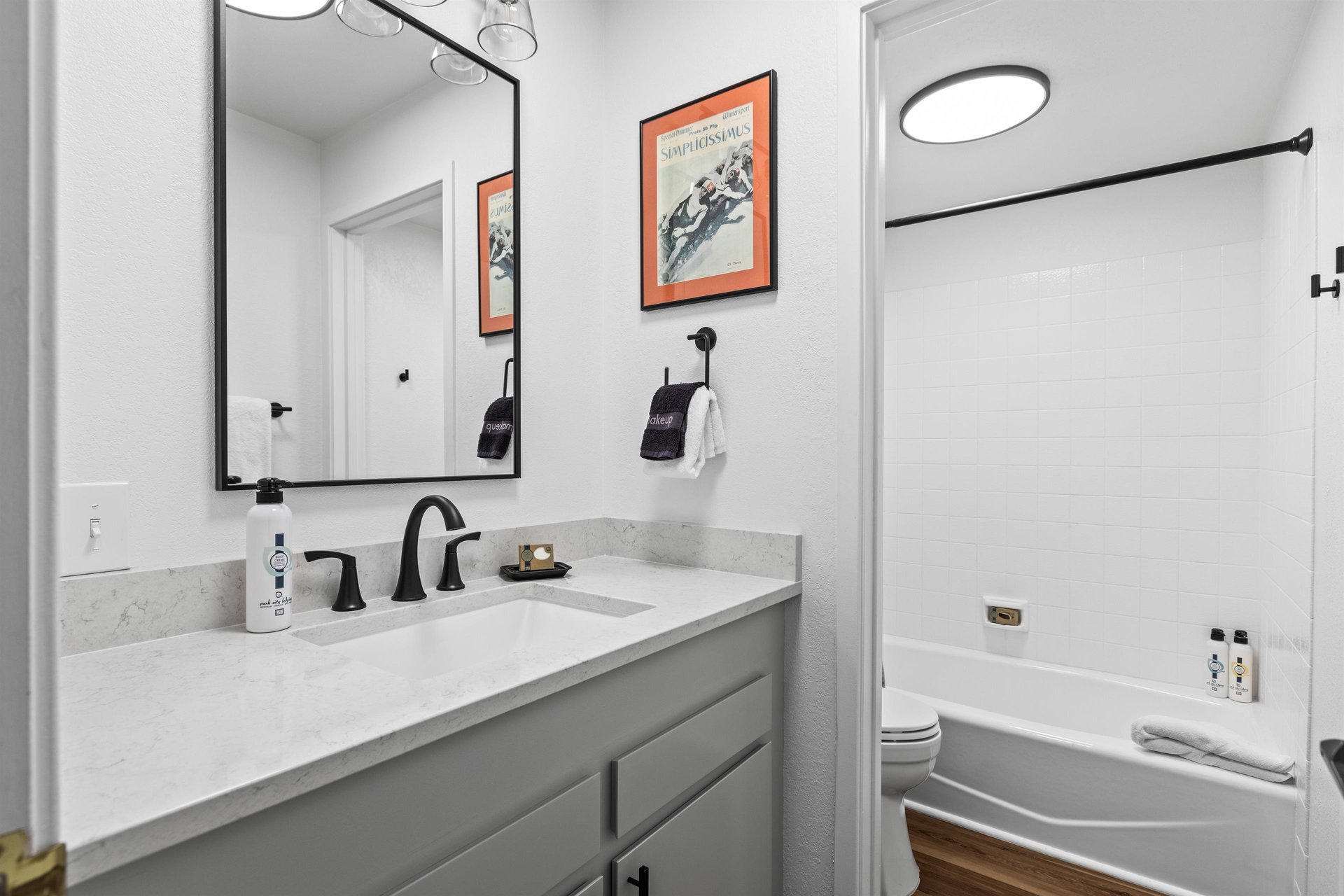 The bathroom with a single sink vanity and a separate water closet with toilet and bathtubshower combination.