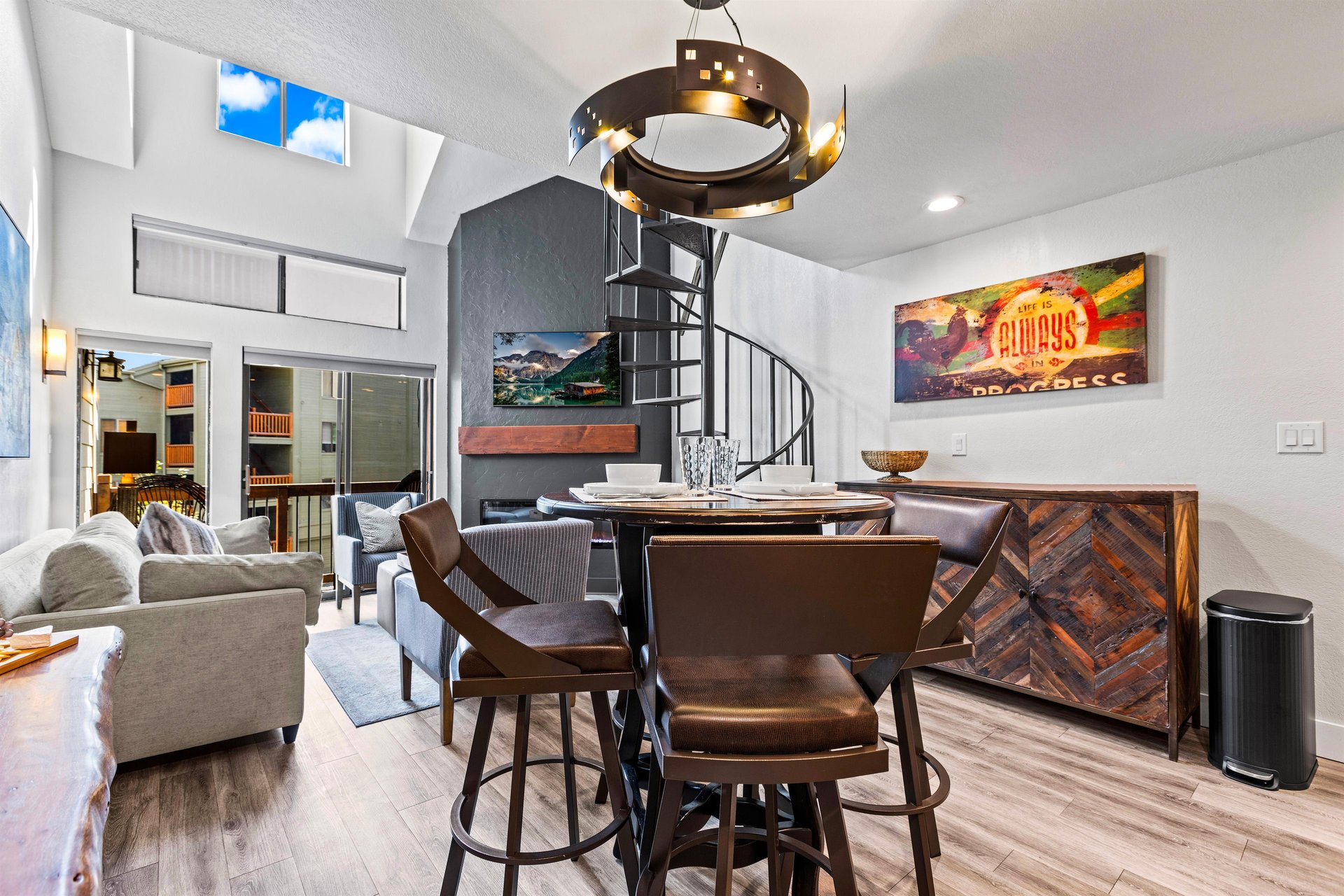 The dining table with seating for four guests and a artistic spiral chandelier.