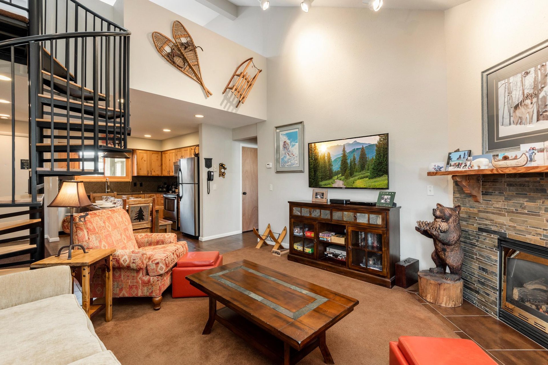 Spacious living room with vaulted ceilings, flatscreen TV, rustic furnishings and mountain décor