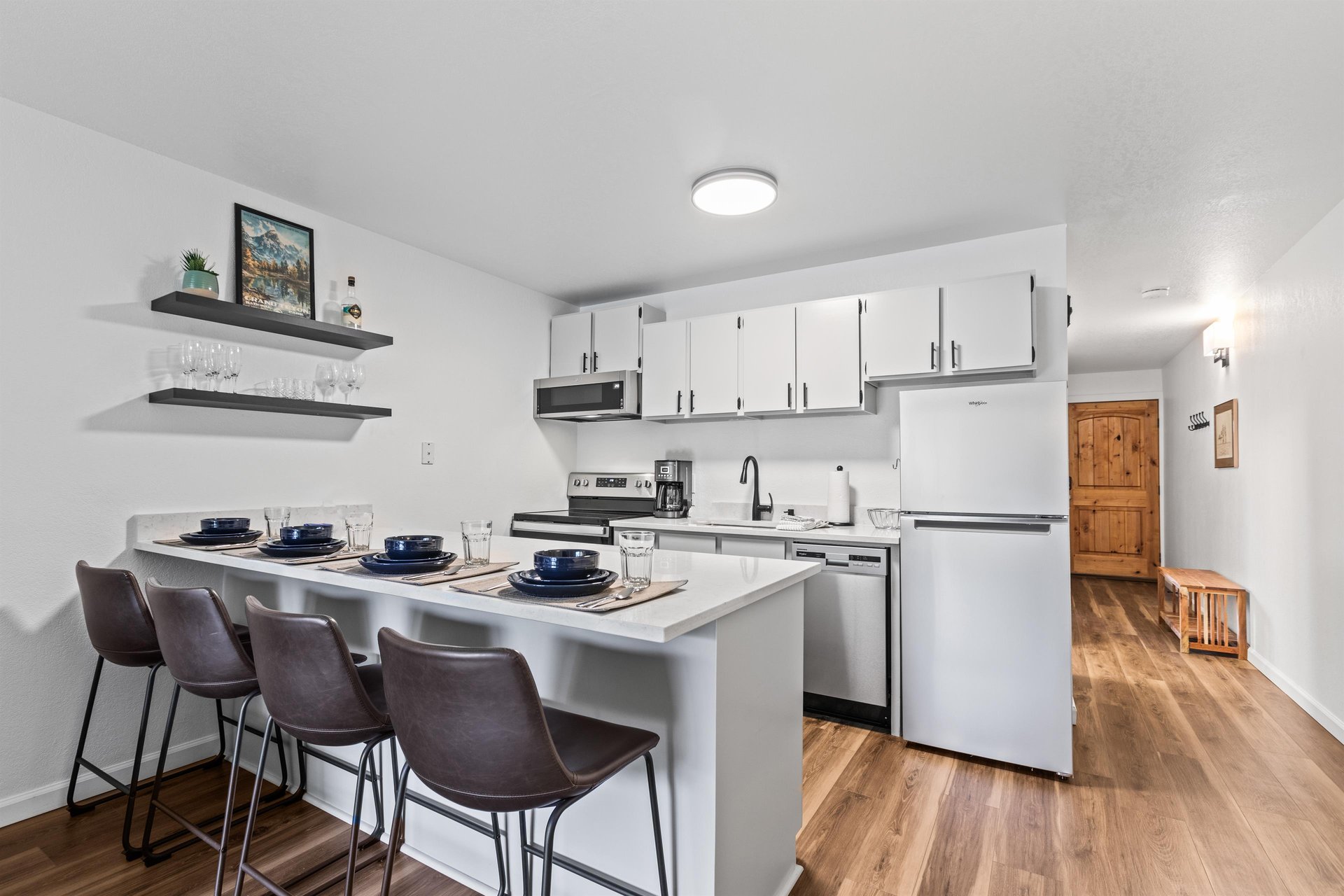 The updated kitchen has stainless steel appliances and light grey cabinets.