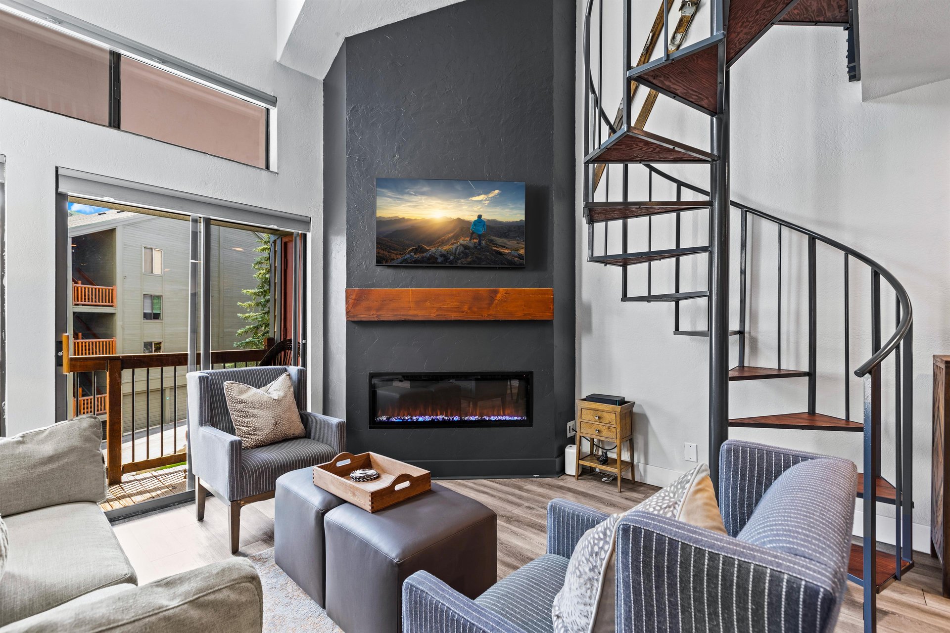Snowcrest 302s living room with a striking grey fireplace wall with modern gas fireplace insert and flat screen TV.