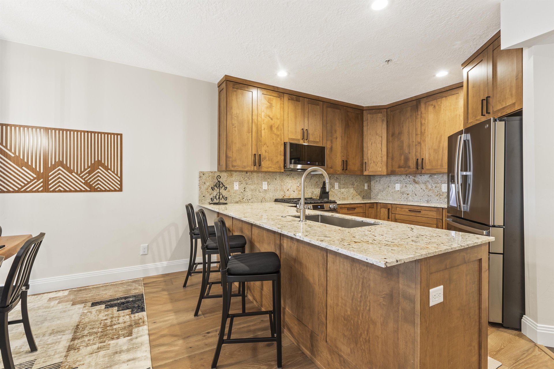 The wellequipped kitchen has beautiful wood cabinets and granite counters.