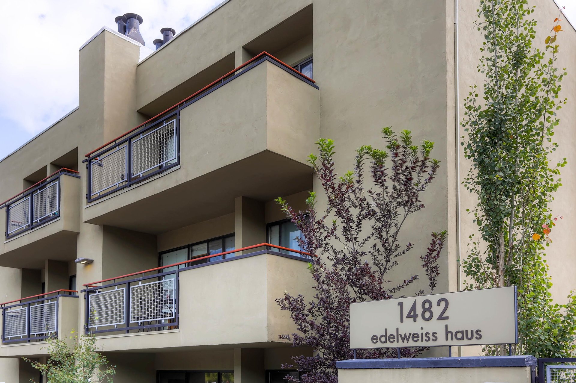 Exterior view of Edelweiss Haus with private balconies and mature landscaping.