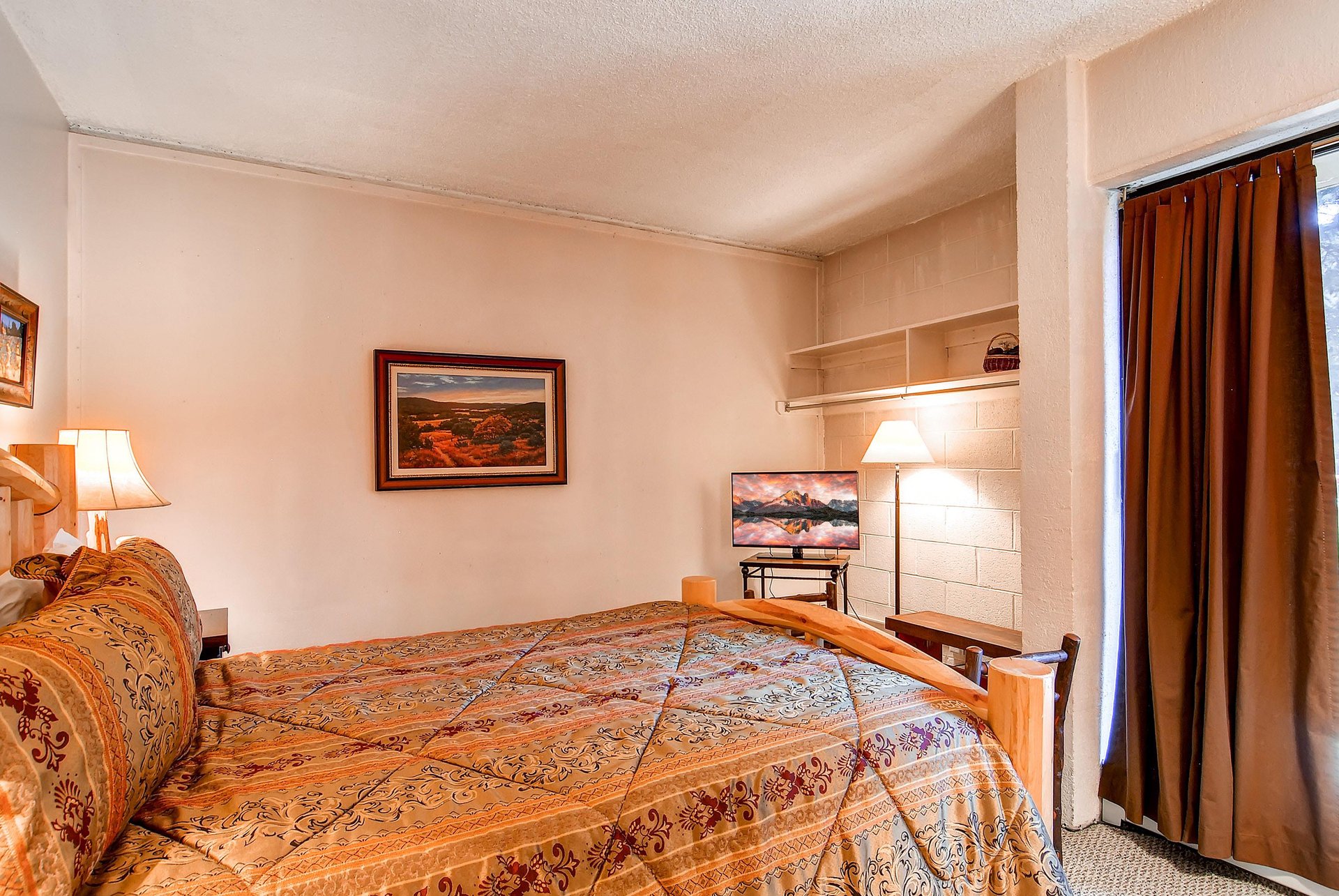 The guest bedroom with a king bed and TV.