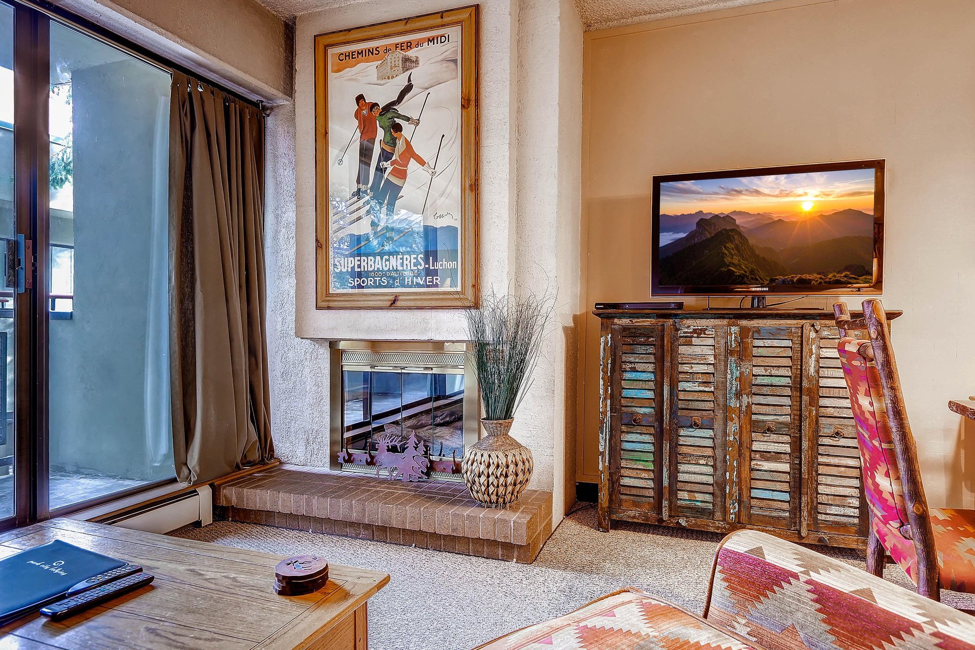 The living room features a cozy gas fireplace, large screen TV, and comfortable furniture.