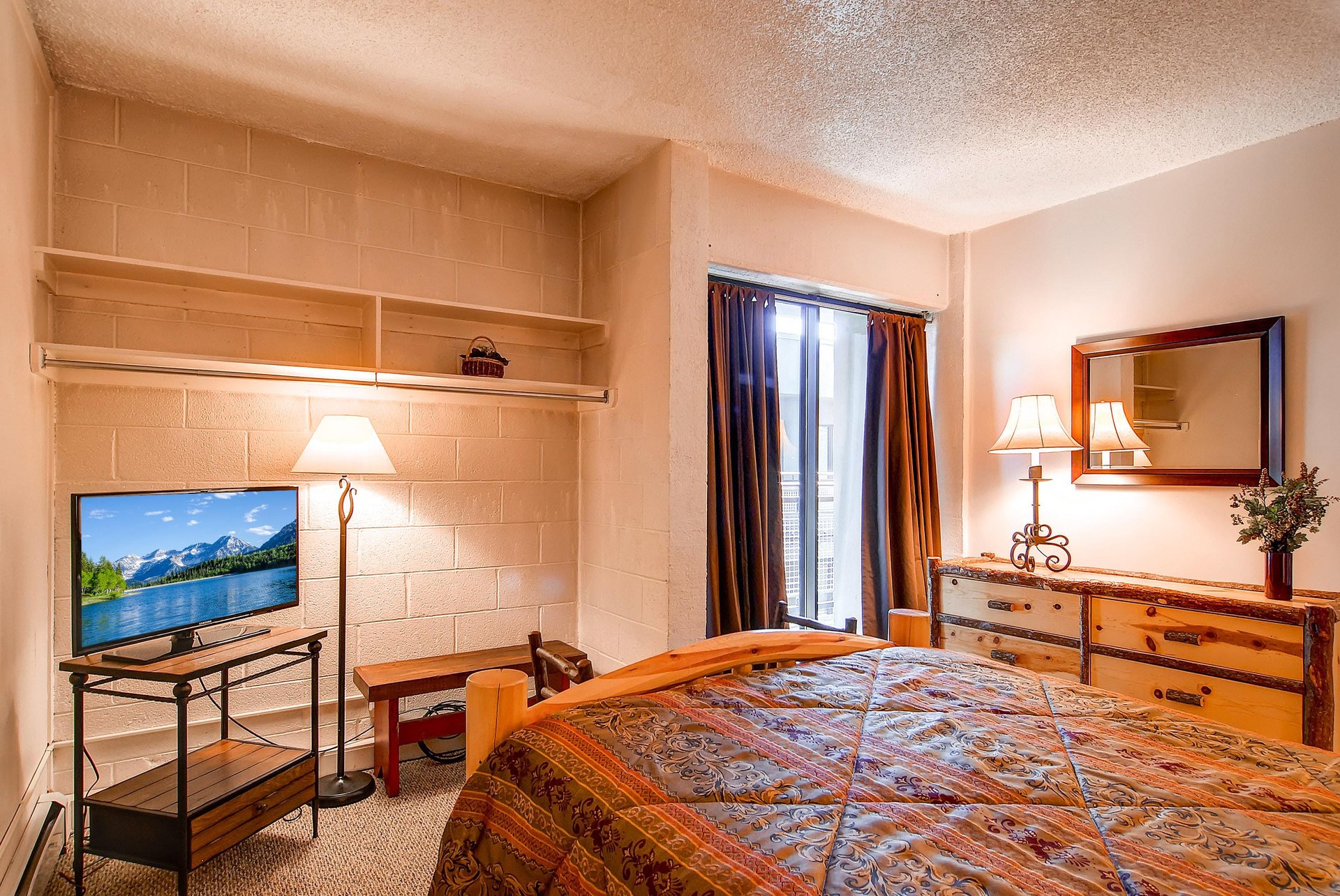 The bedroom with a queen bed and TV.