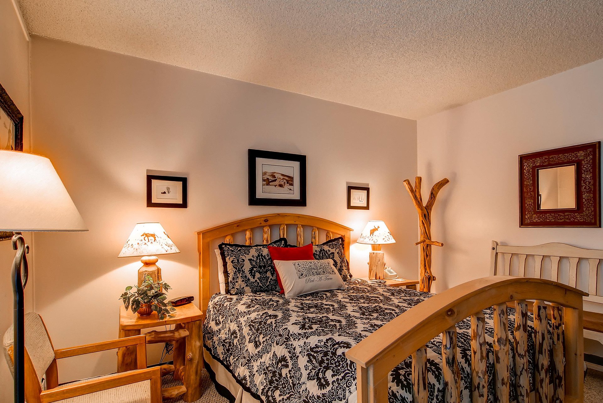 Room features a king sized bed with cozy lodge decor.