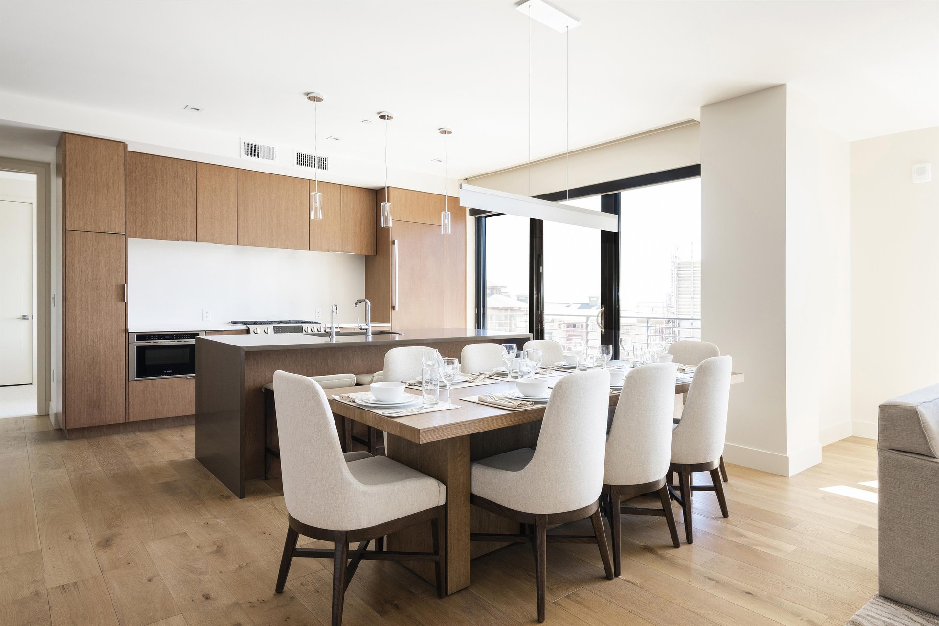 Expansive dining room, solid wood table with seating for 8 in high back upholstered chairs, hardwood floors throughout.