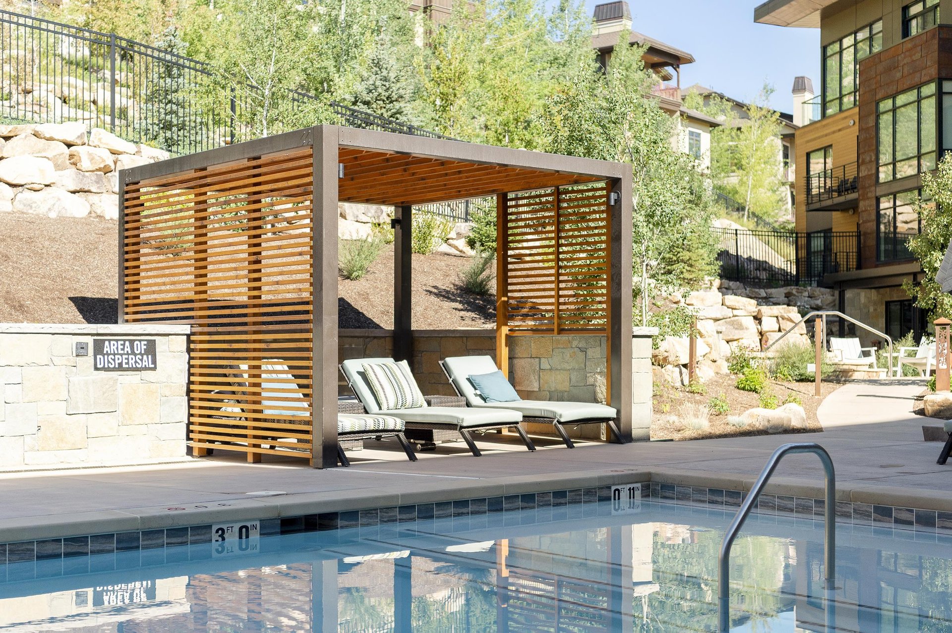 Poolside relaxation, three lounge chairs in the shade structure alongside the pool at Lift Condos in the Canyons Village.