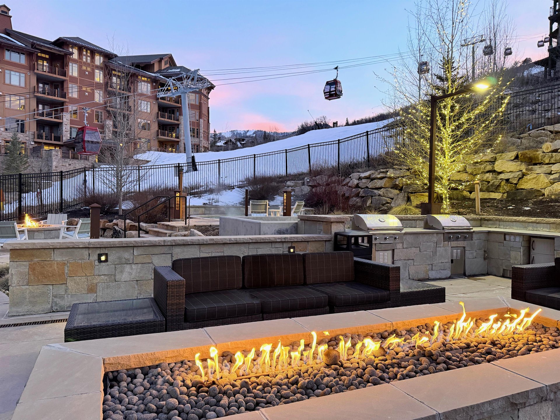 The stunning Lift Condominium outdoor firepit and grilling area, and the Sunrise Gondola behind it.
