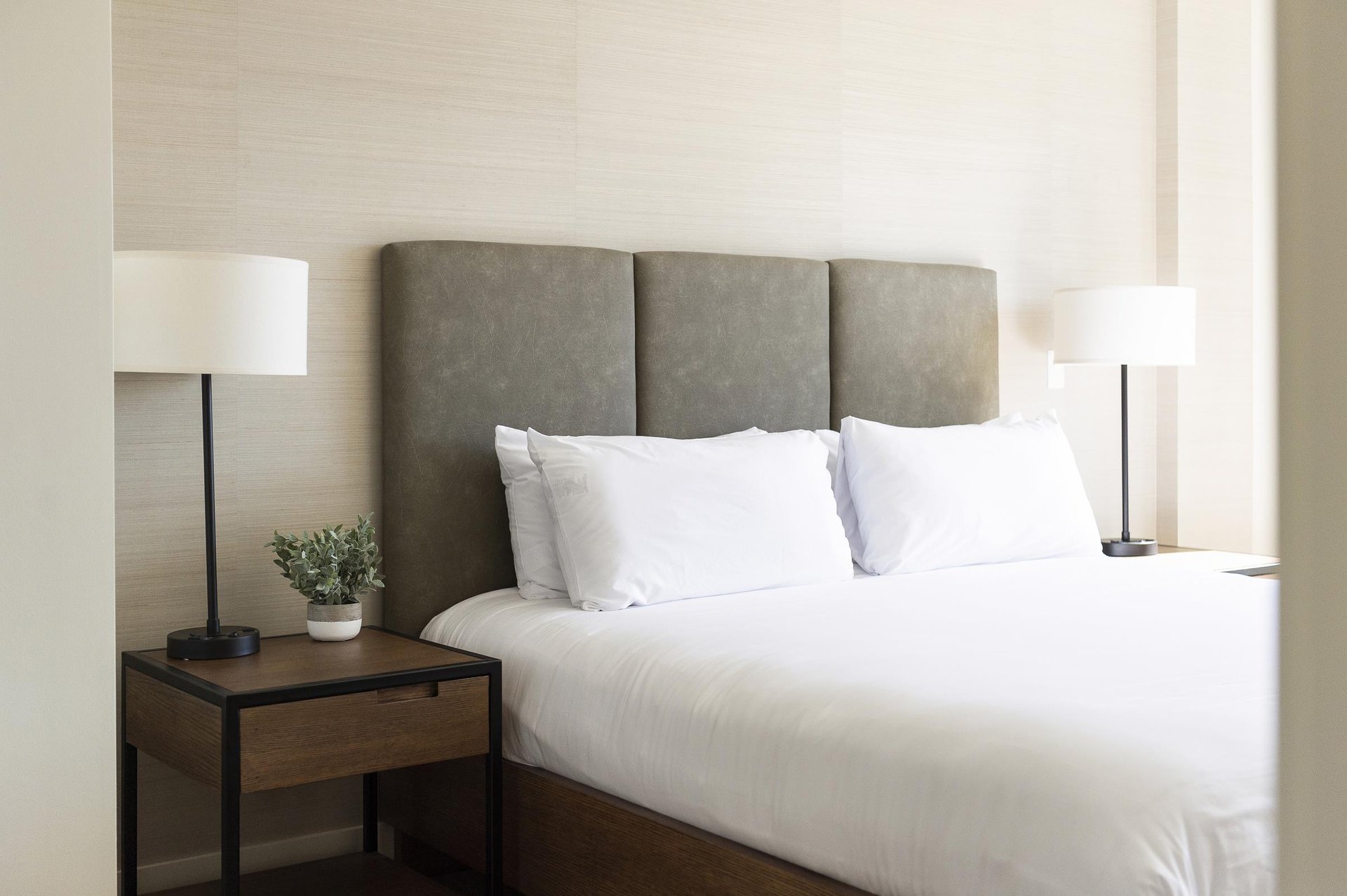 King bed in the main bedroom with wooden side tables and tableside lamps.