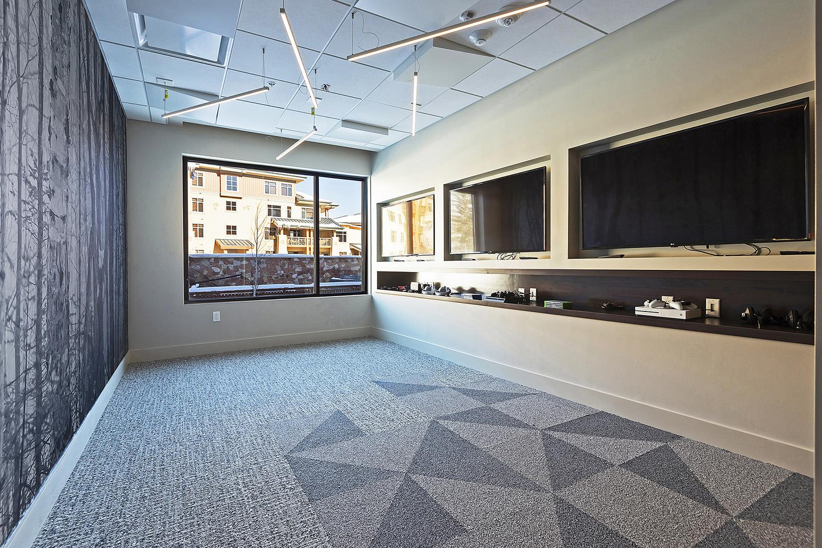 Lift teen lounge with 3 flat screen TVs and gaming consoles.