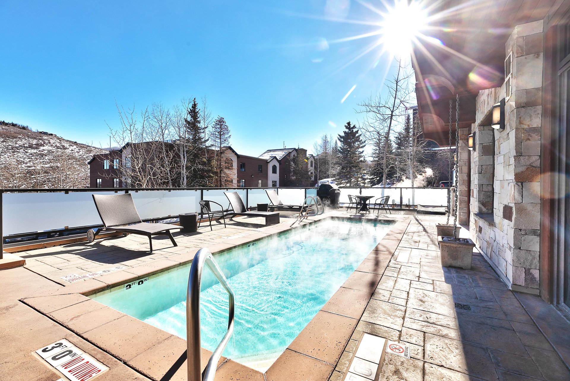 Outdoor heated community pool and patio surrounded by snow at Lowell Condominiums in Park City.