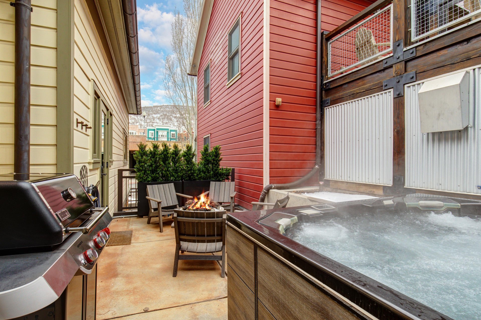 The heated patio offers a hot tub, fire table with seating for four, and BBQ gas grill.