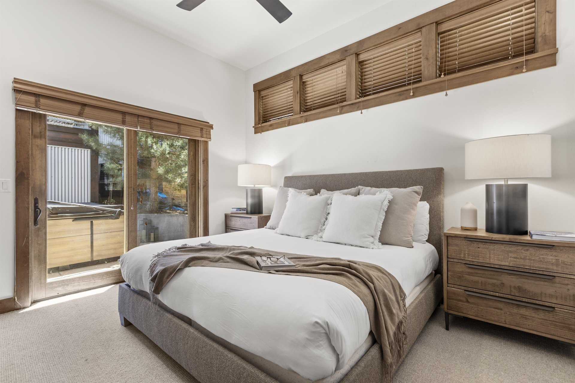 Town Lift Chalets second bedroom with large glass sliding glass doors leading to a patio with a hot tub.