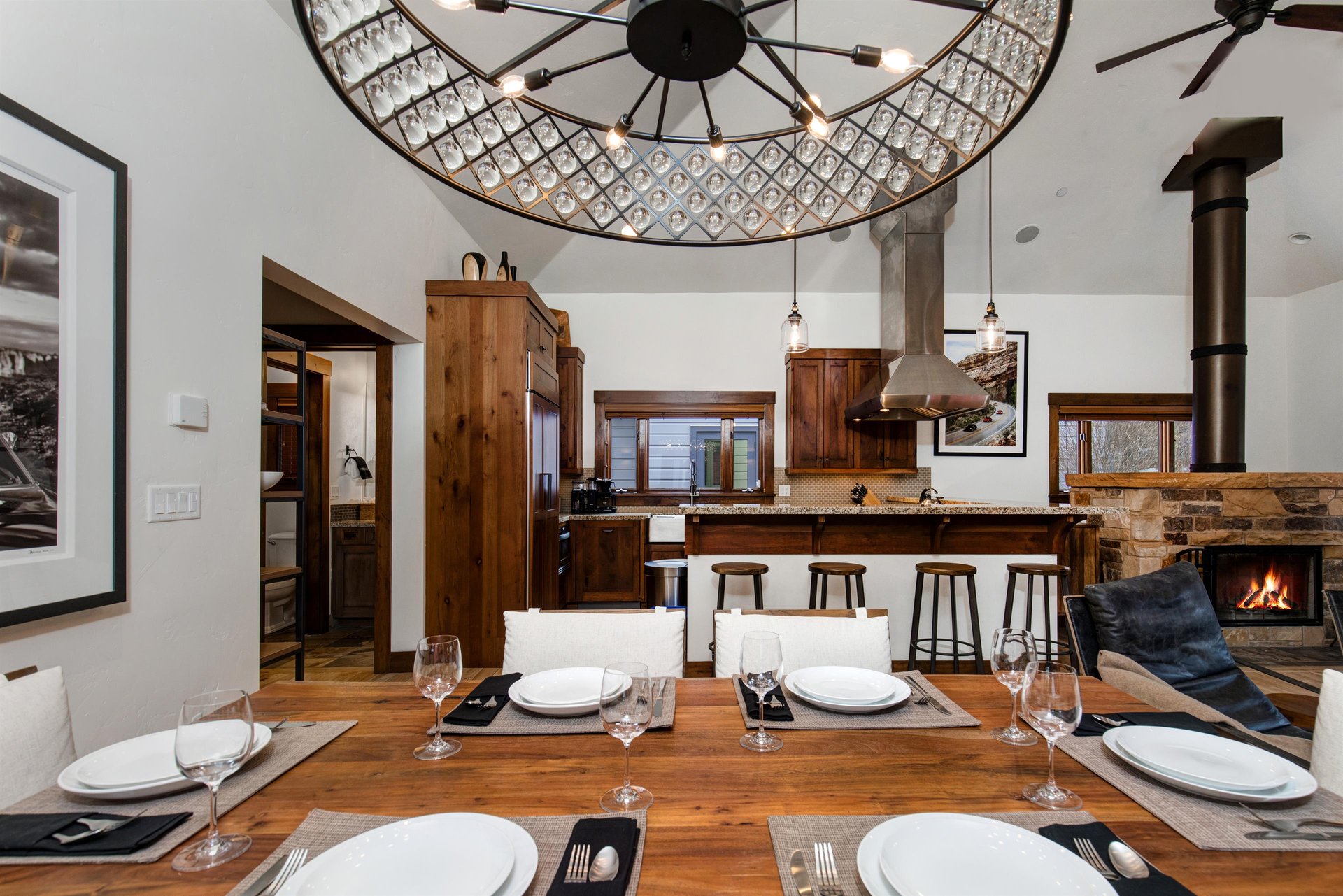 The dining area has an inviting table set for six guests with a chandelier for perfect lighting.
