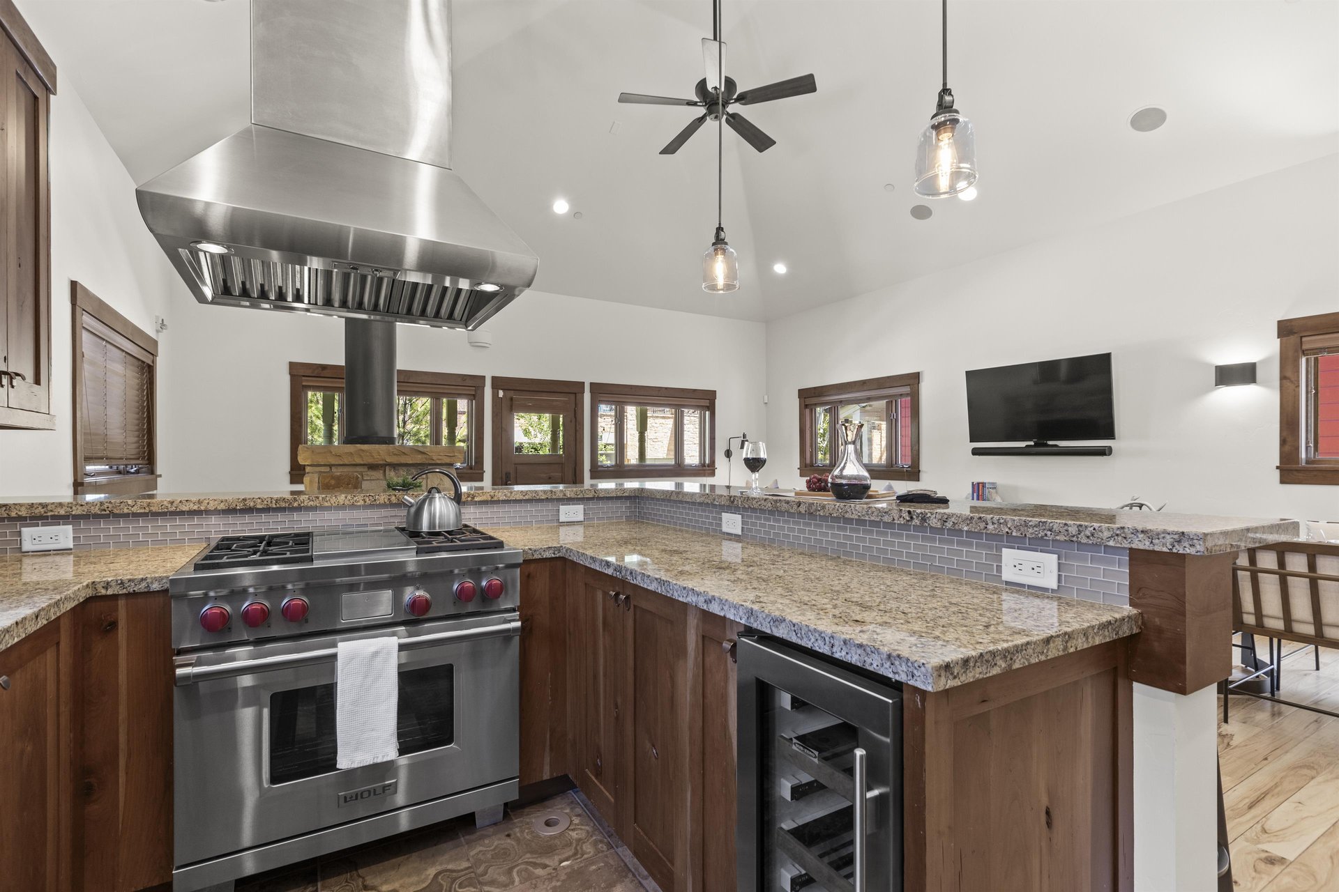Town Lift Chalets kitchen with breakfast bar, stainless steel Wolf range, stainless hood vent, and wine fridge.