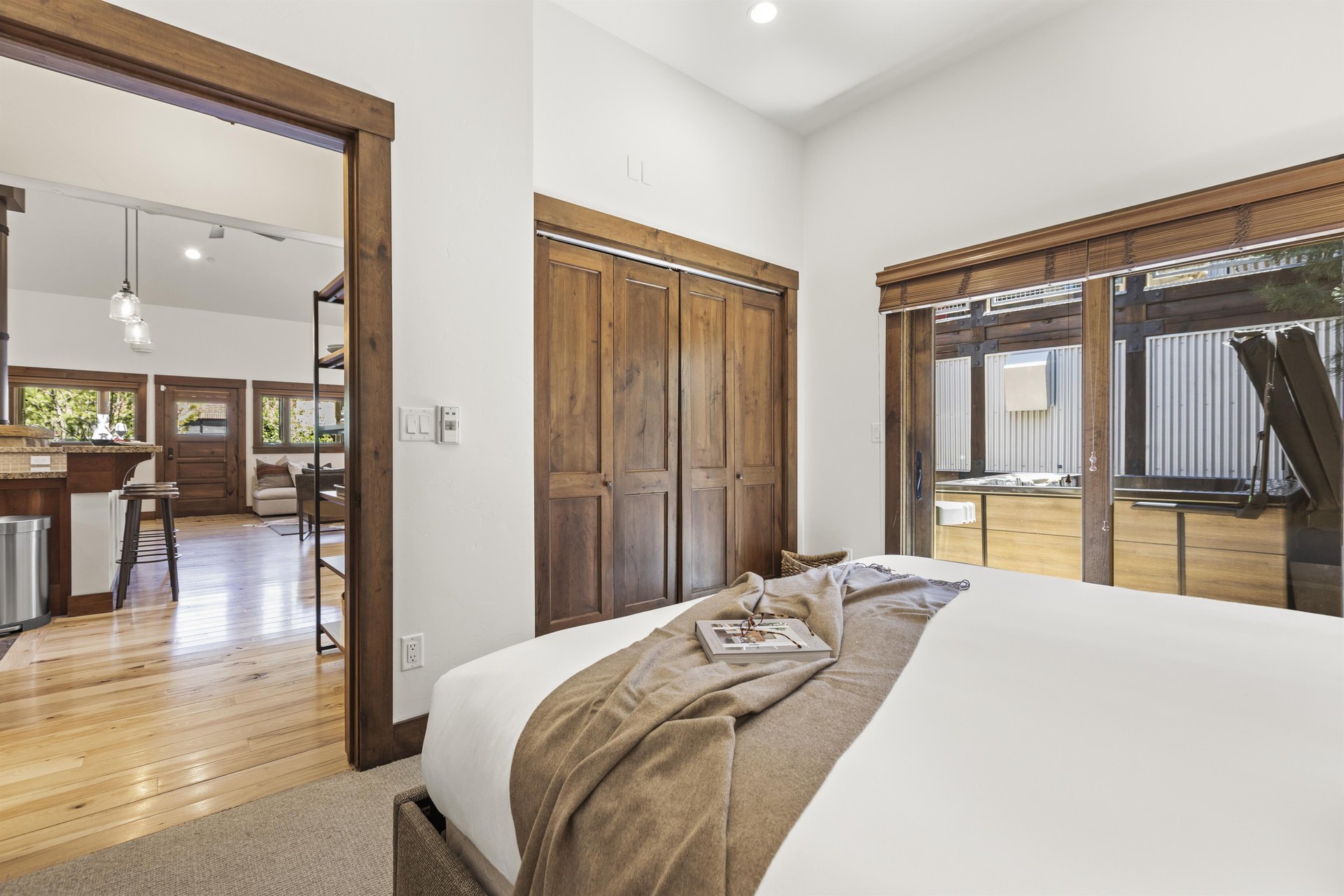 Town Lift Chalets second bedroom with sliding glass doors and lovely wooden blinds that are pulled up to allow light in.