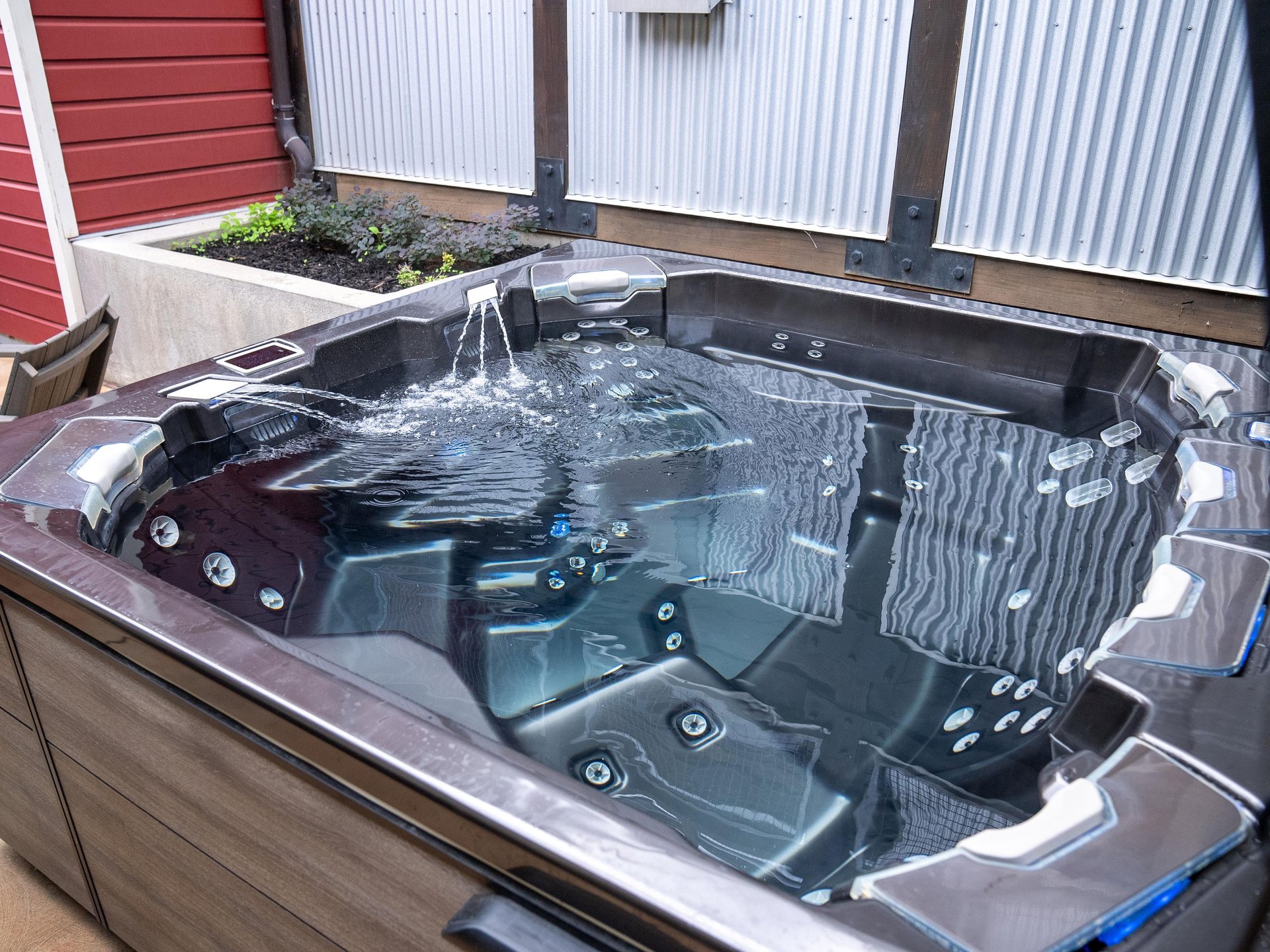 A private hot tub with crystal clear water, a water fountain, and many seats and jets.