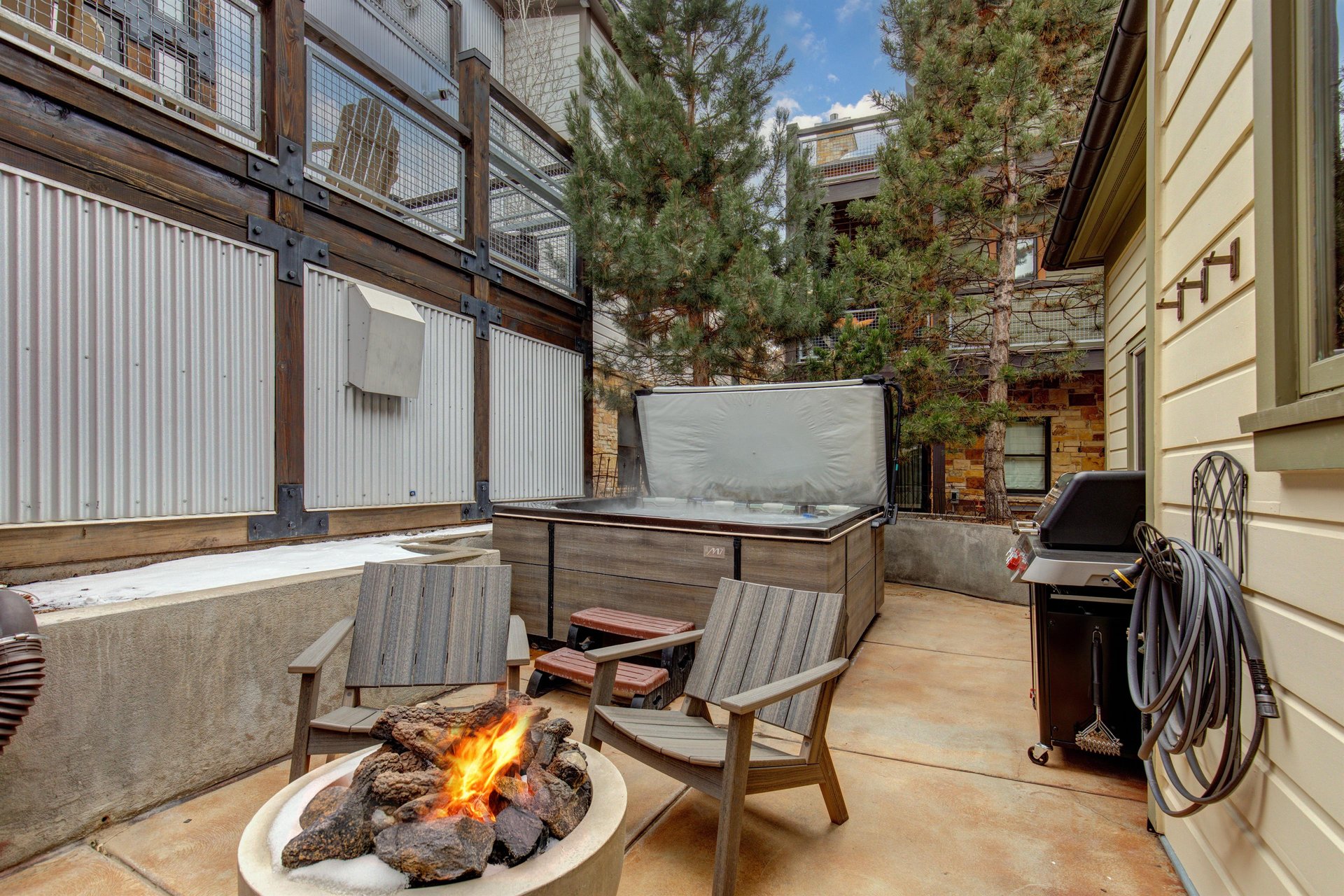 The heated patio offers a hot tub, fire table with seating for four, and BBQ gas grill.