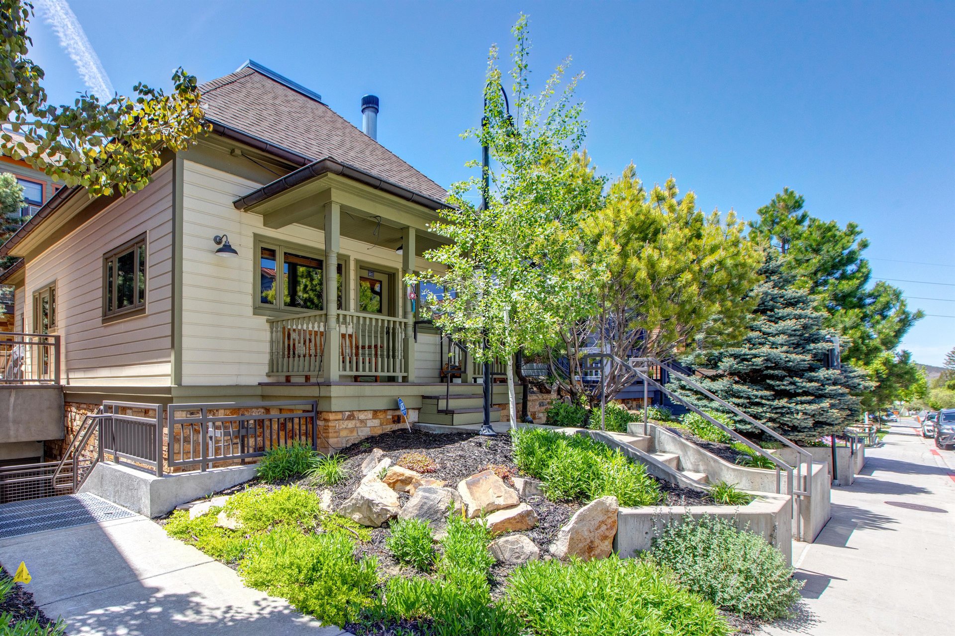 Town Lift Chalet has nice trees and shrubs in the front yard and stairs leading to the sidewalk.