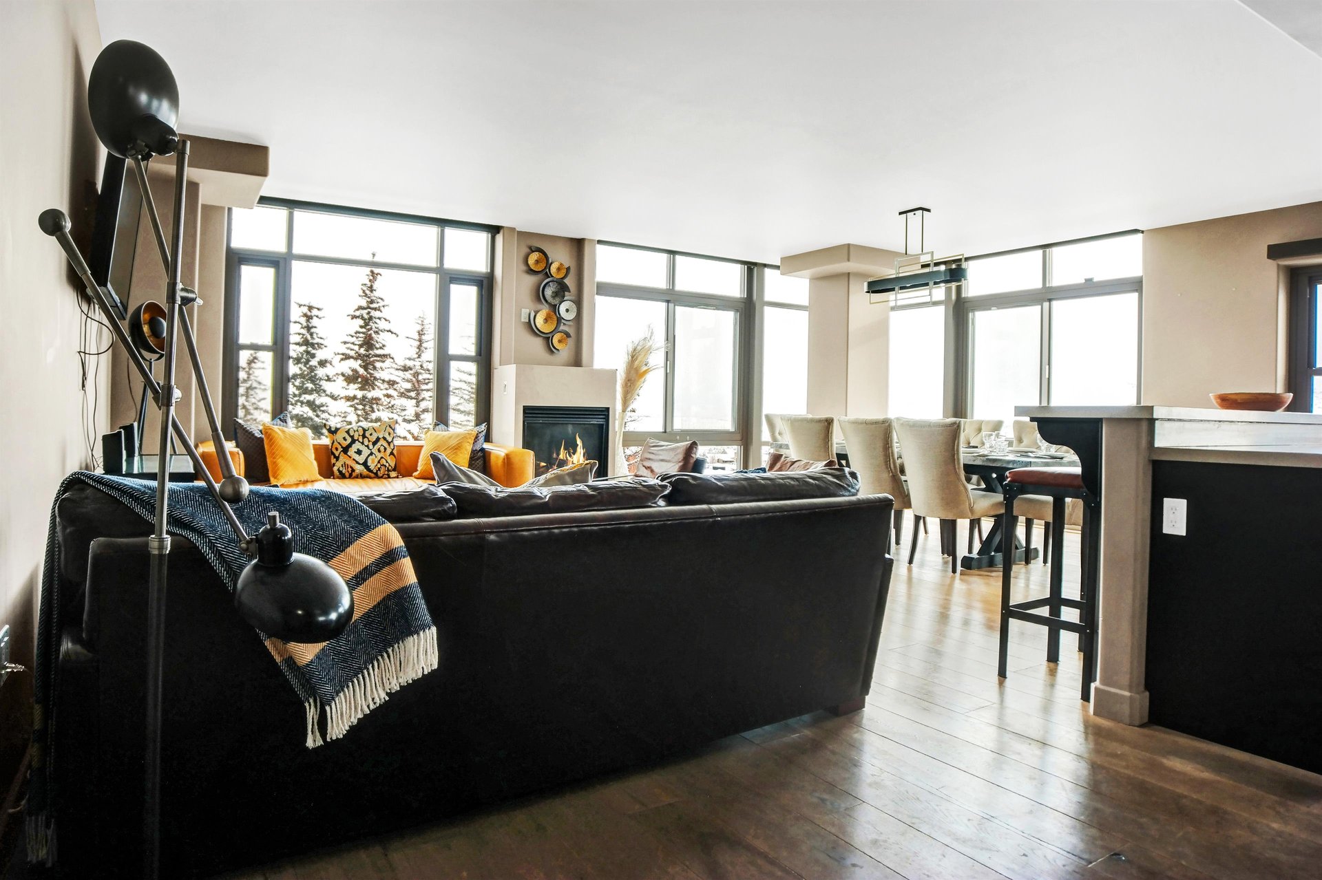 Open living room with comfortable seating, wood floors and large windows overlooking the surrounding mountains.